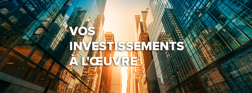 Vos investissements à l’œuvre — immeubles de bureaux vitrés reflétant la lumière du soleil couchant.