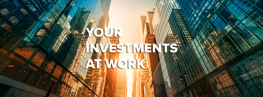Your investments at work — glass office buildings reflecting the setting sun.