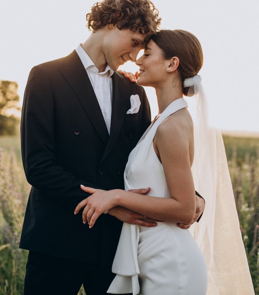 bride and groom posing in fields at Arizona wedding show