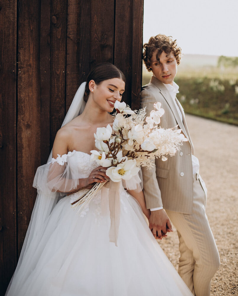 bride and groom posing in fields at Arizona wedding show
