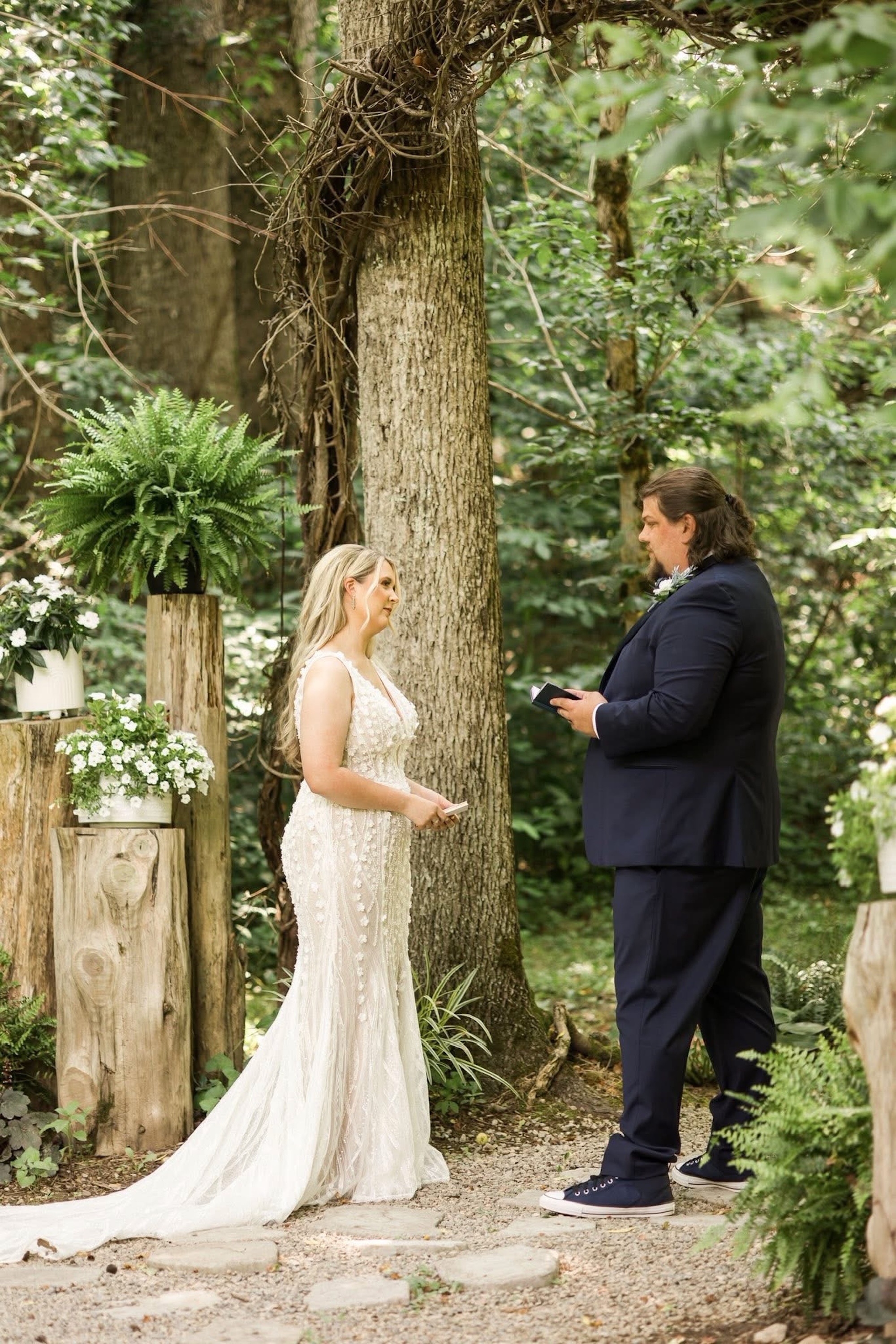Bride and groom exchange vows in the forest path at The Barn at Cedar Grove near Burkesville, KY'