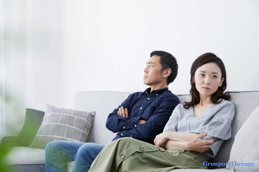 Couple sitting apart on a couch during relationship conflict