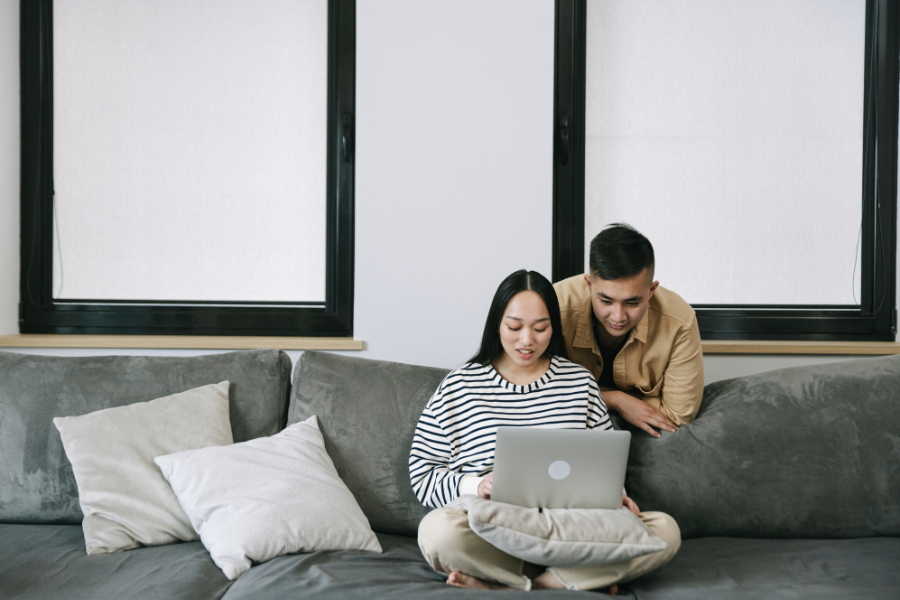 Couple using a laptop together at home for an online couples therapy session