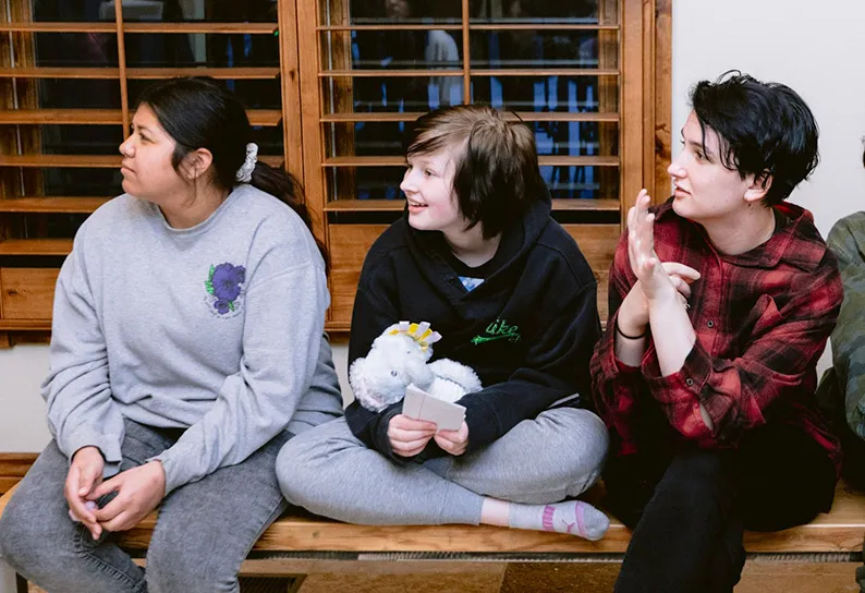 Three girls listen to the lesson