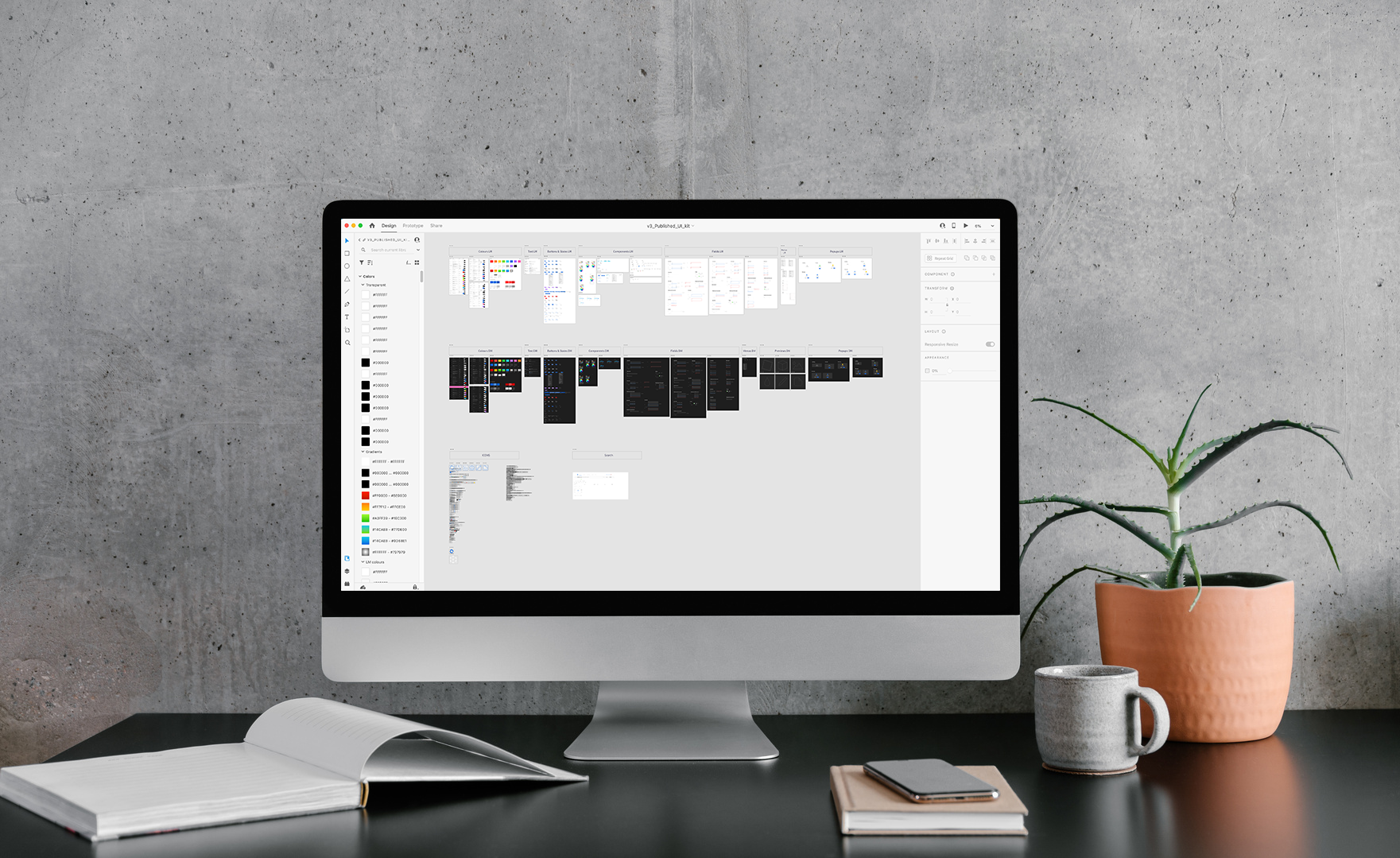 An iMac on a desk showing the design system component library in Figma.