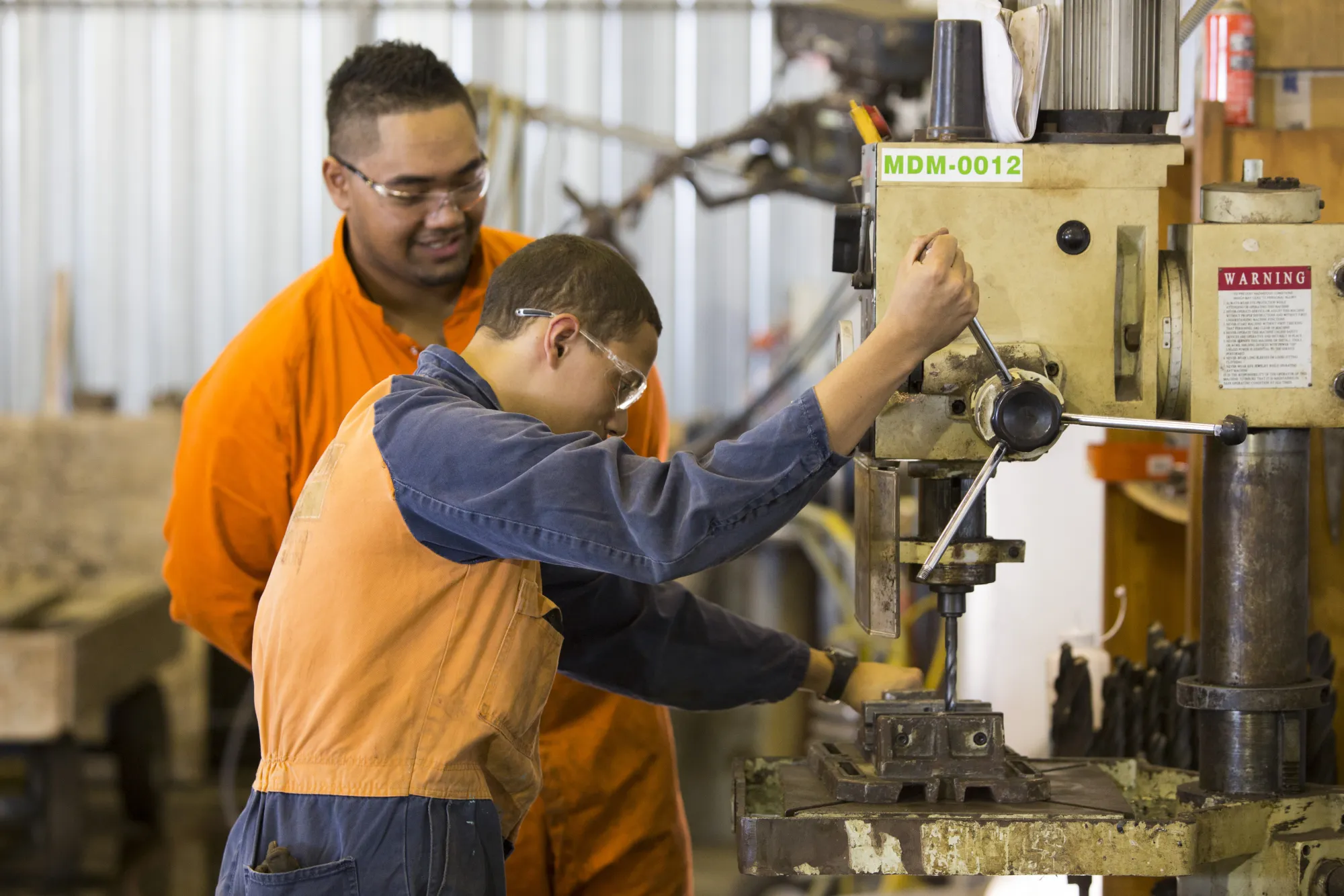 Coach and apprentice at a drill press
