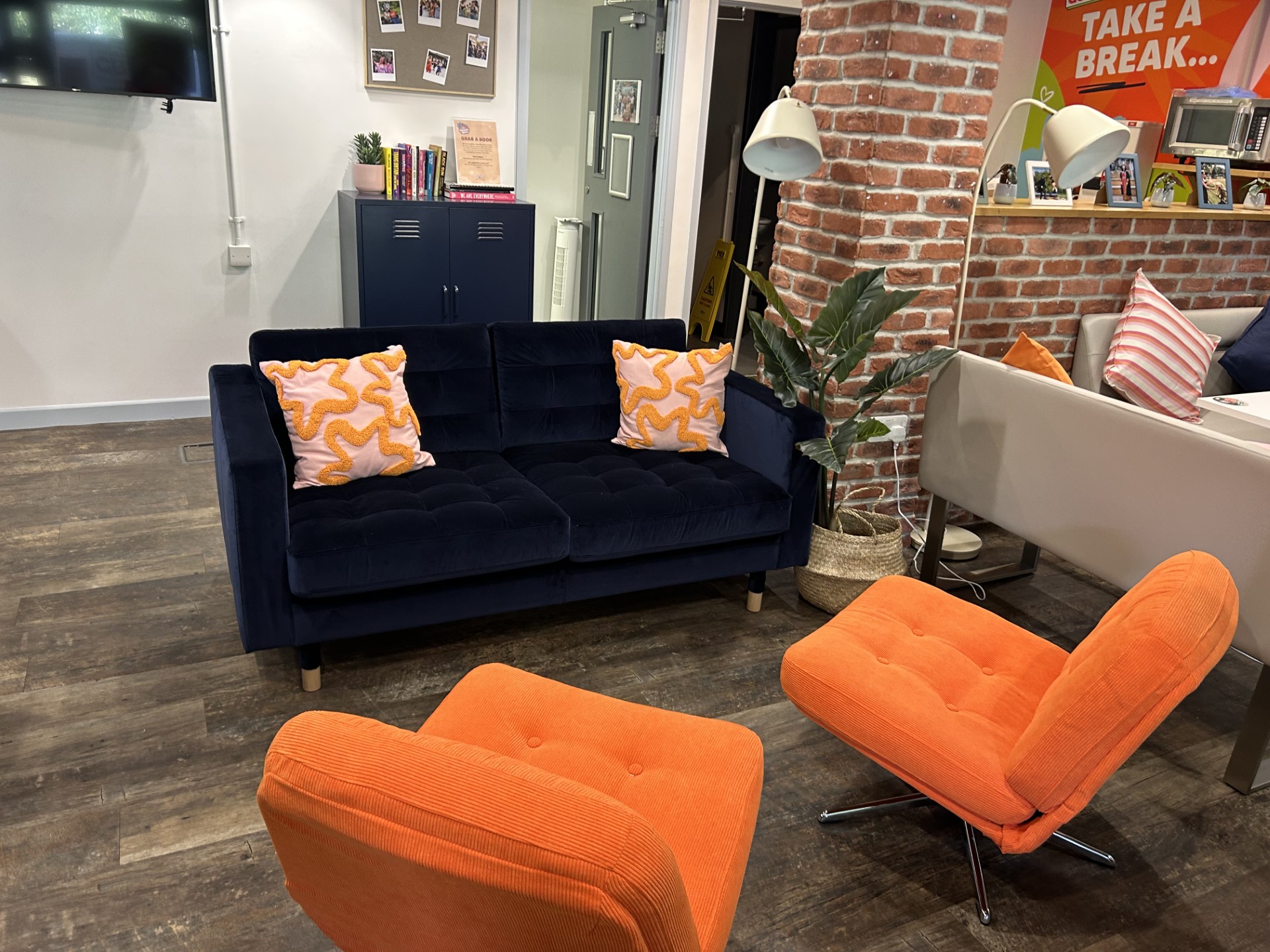 Navy sofa with orange swivel chairs and wavy cushions