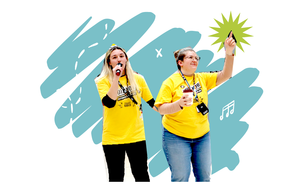 Two women speaking into a mic on a stage