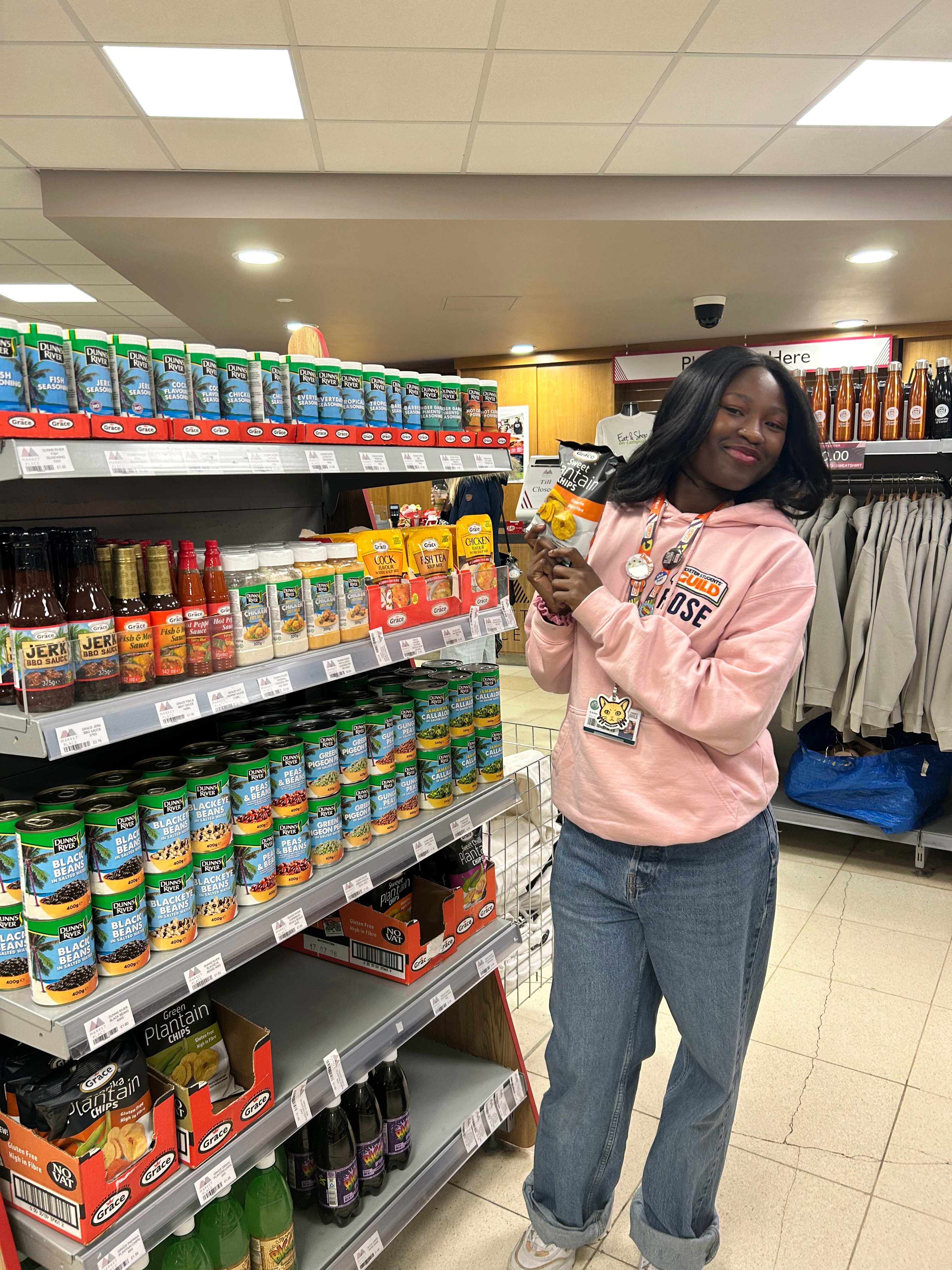 A female student holding some plantain chips in forum marketplace
