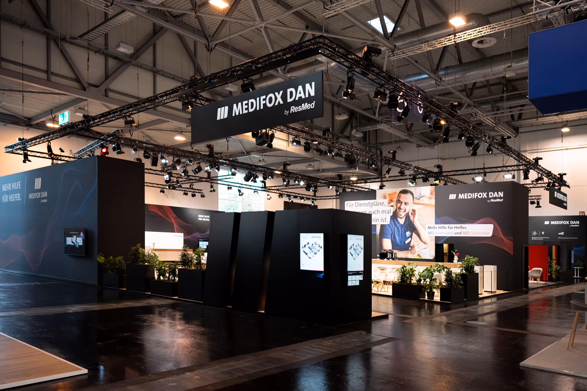 600 m² großer Messestand von Medifox Dan auf der Altenpflege Messe 2024 in Essen mit modernen Beratungsinseln für MD Ambulant und MD Stationär.