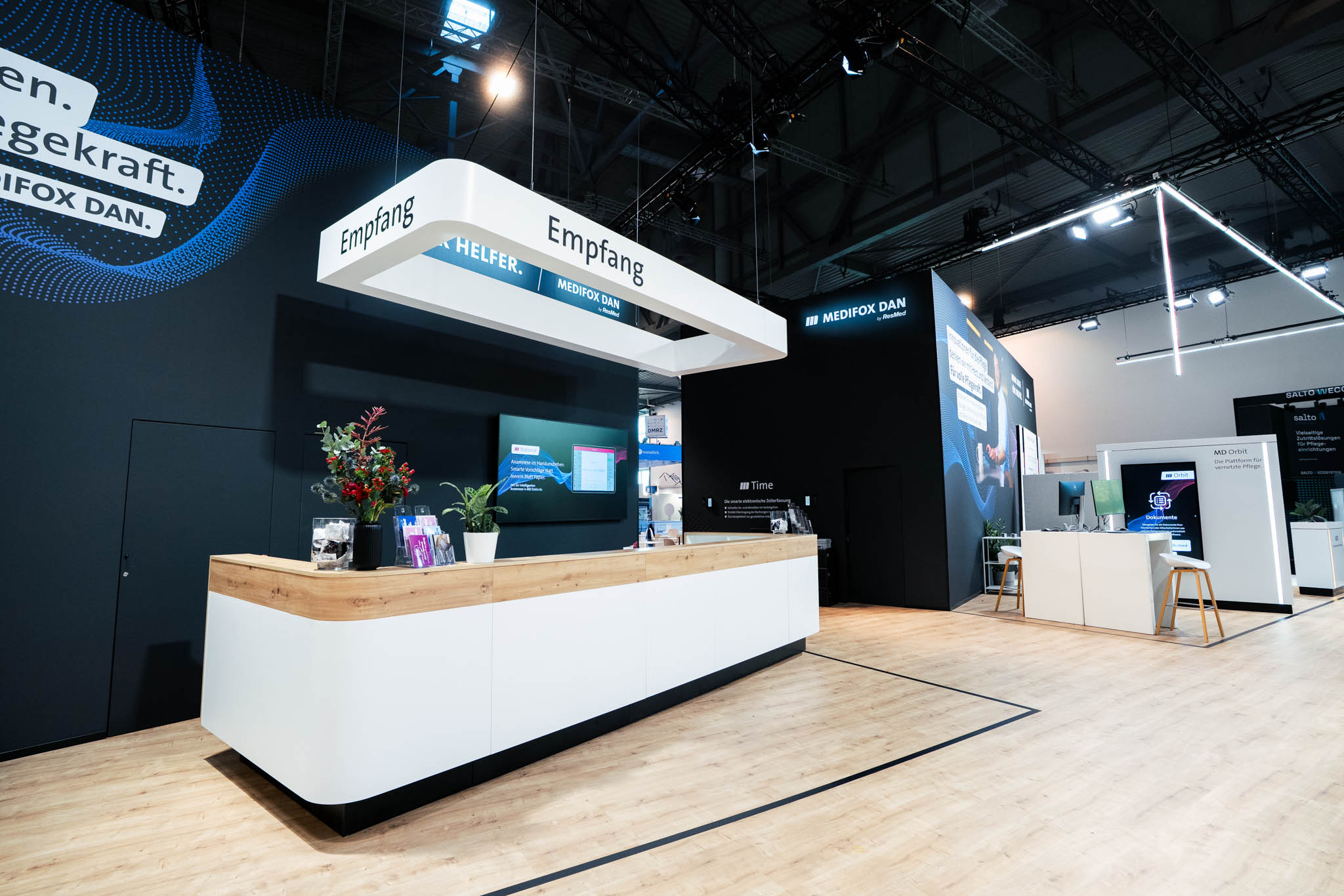 708 m² großer Messestand von MEDIFOX DAN auf der Altenpflege Messe 2026 in Essen mit Innovation Zone, Beratungsräumen, Café und modernem Messebau.