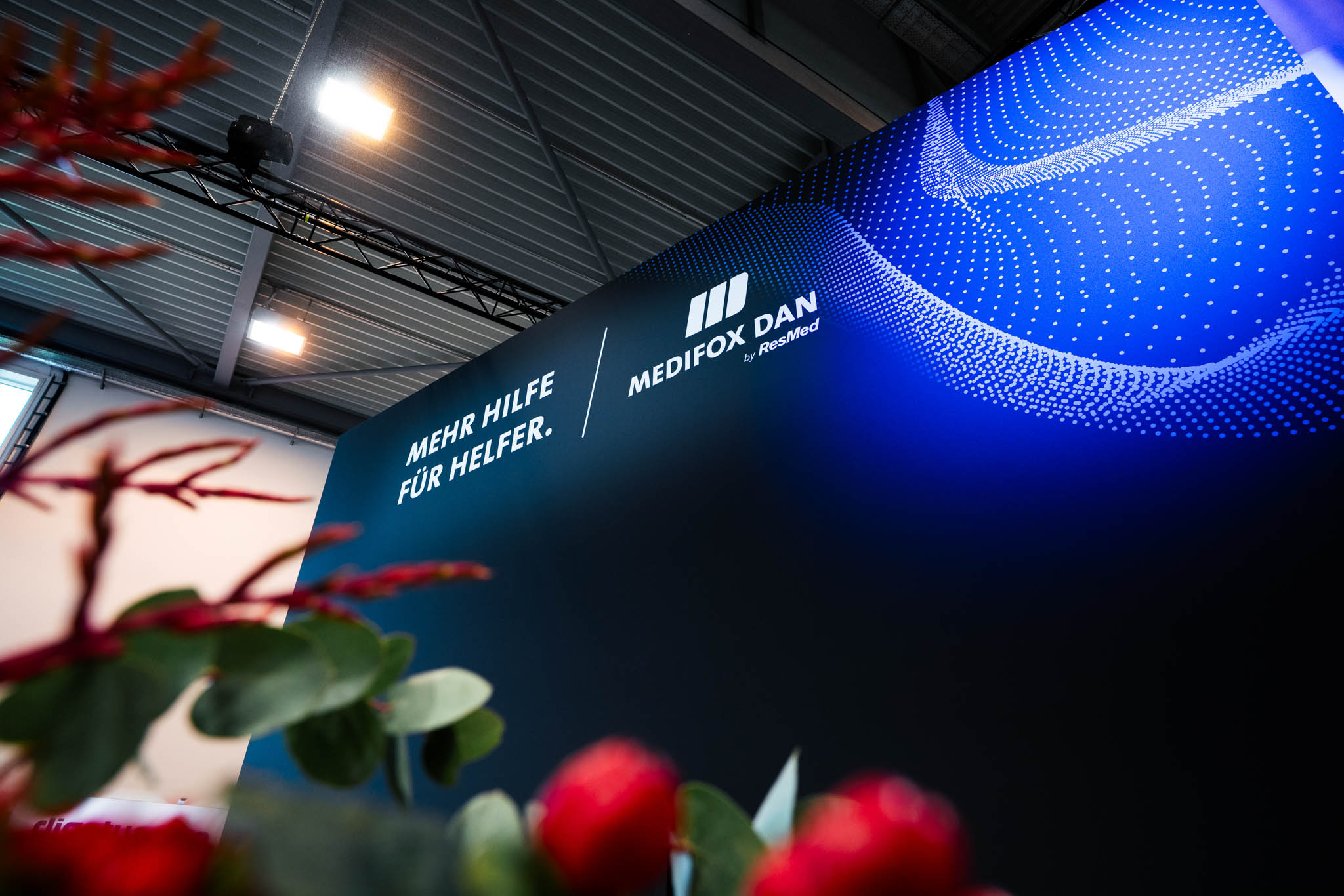 708 m² großer Messestand von MEDIFOX DAN auf der Altenpflege Messe 2026 in Essen mit Innovation Zone, Beratungsräumen, Café und modernem Messebau.