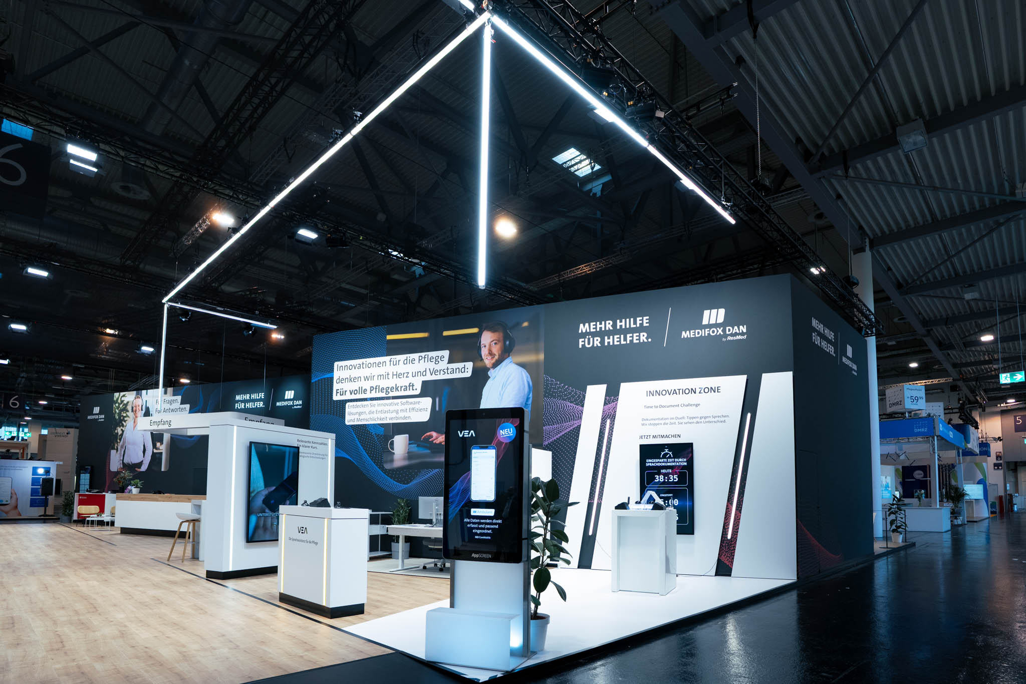 708 m² großer Messestand von MEDIFOX DAN auf der Altenpflege Messe 2026 in Essen mit Innovation Zone, Beratungsräumen, Café und modernem Messebau.