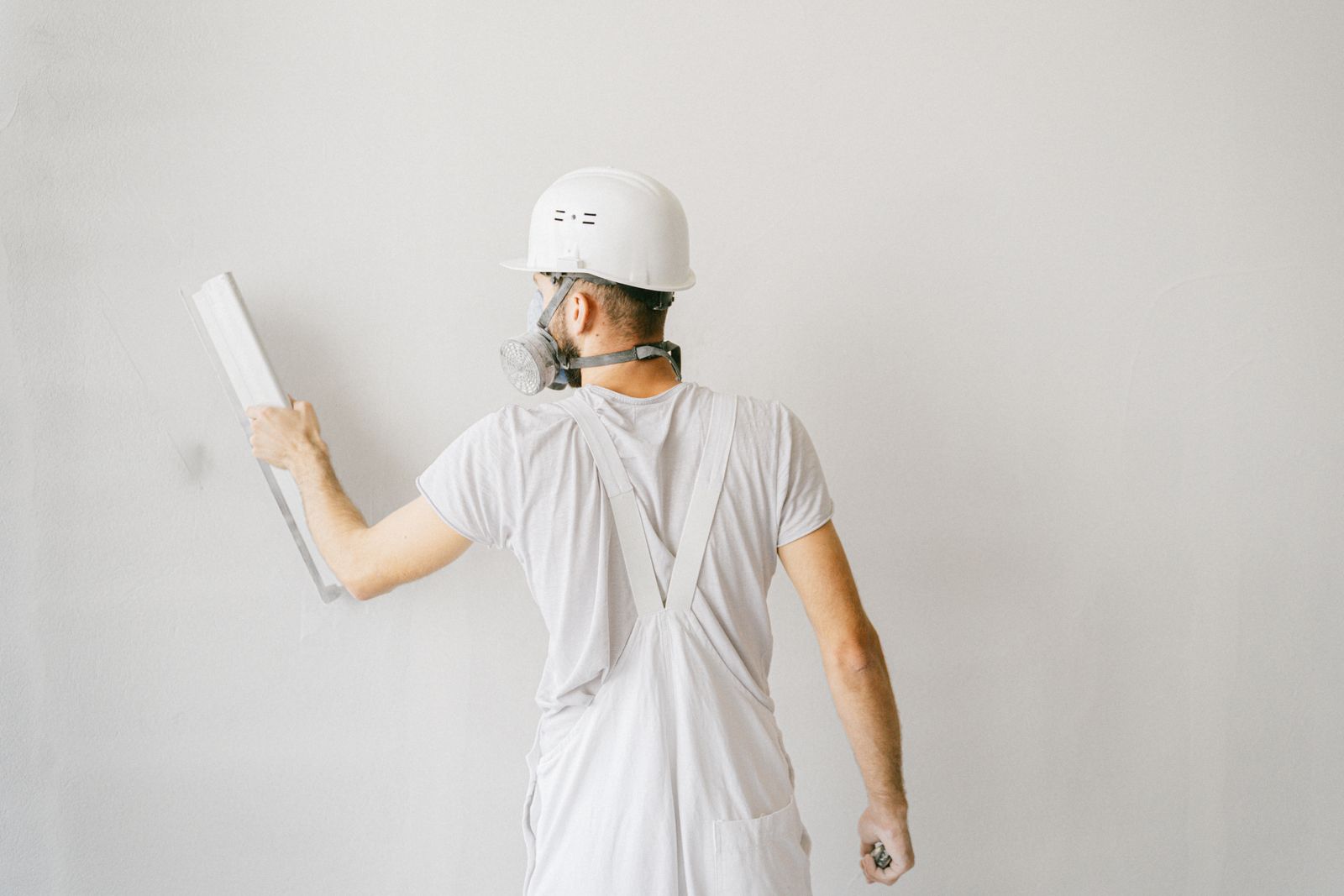 Ouvrier protégé préparant un mur lors de travaux de rénovation