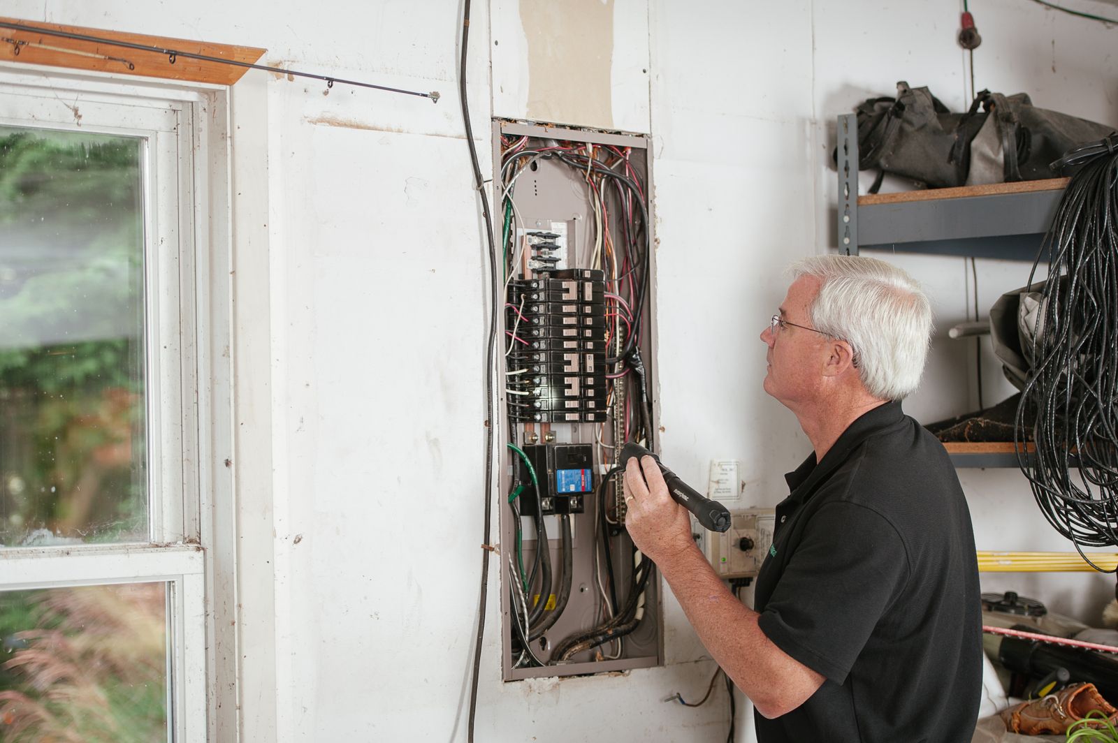 Électricien inspectant le tableau électrique d’un logement