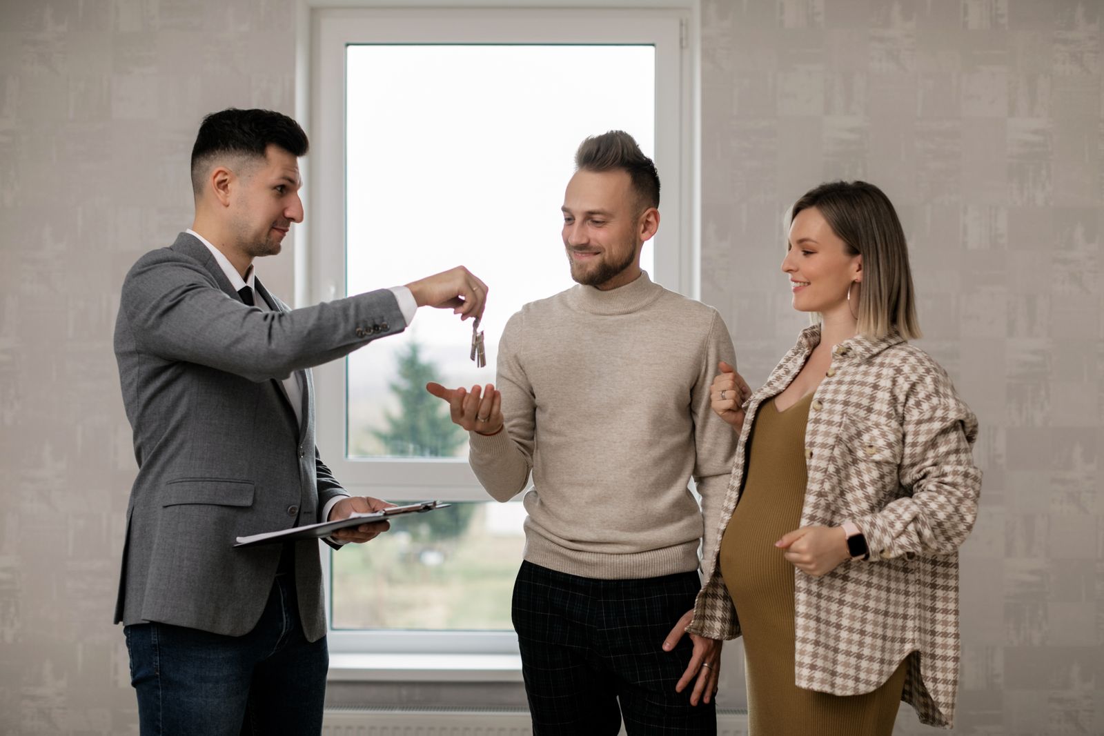 Agent immobilier remettant les clés d’un logement à de nouveaux locataires