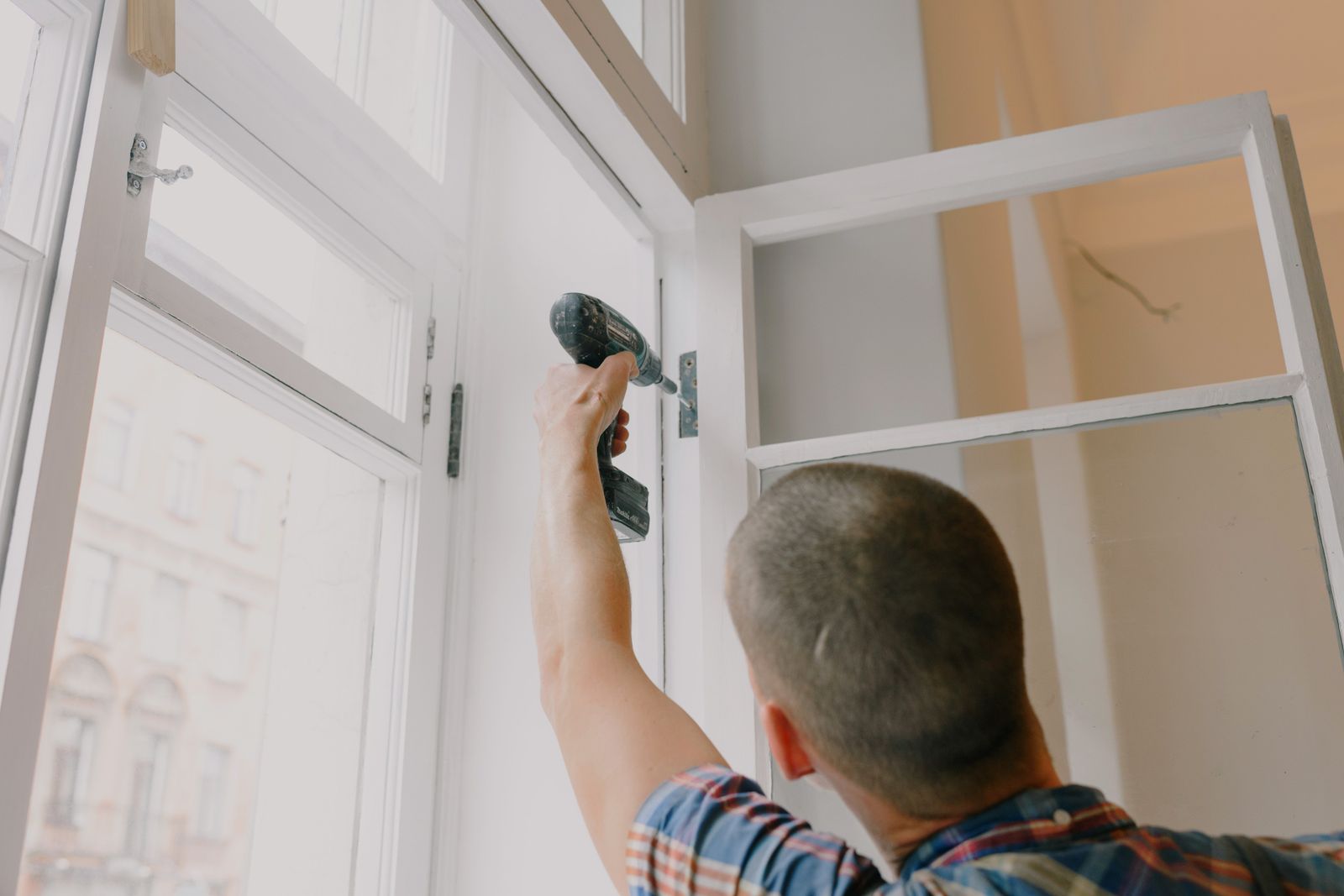 Artisan remplaçant une fenêtre lors d’une rénovation énergétique