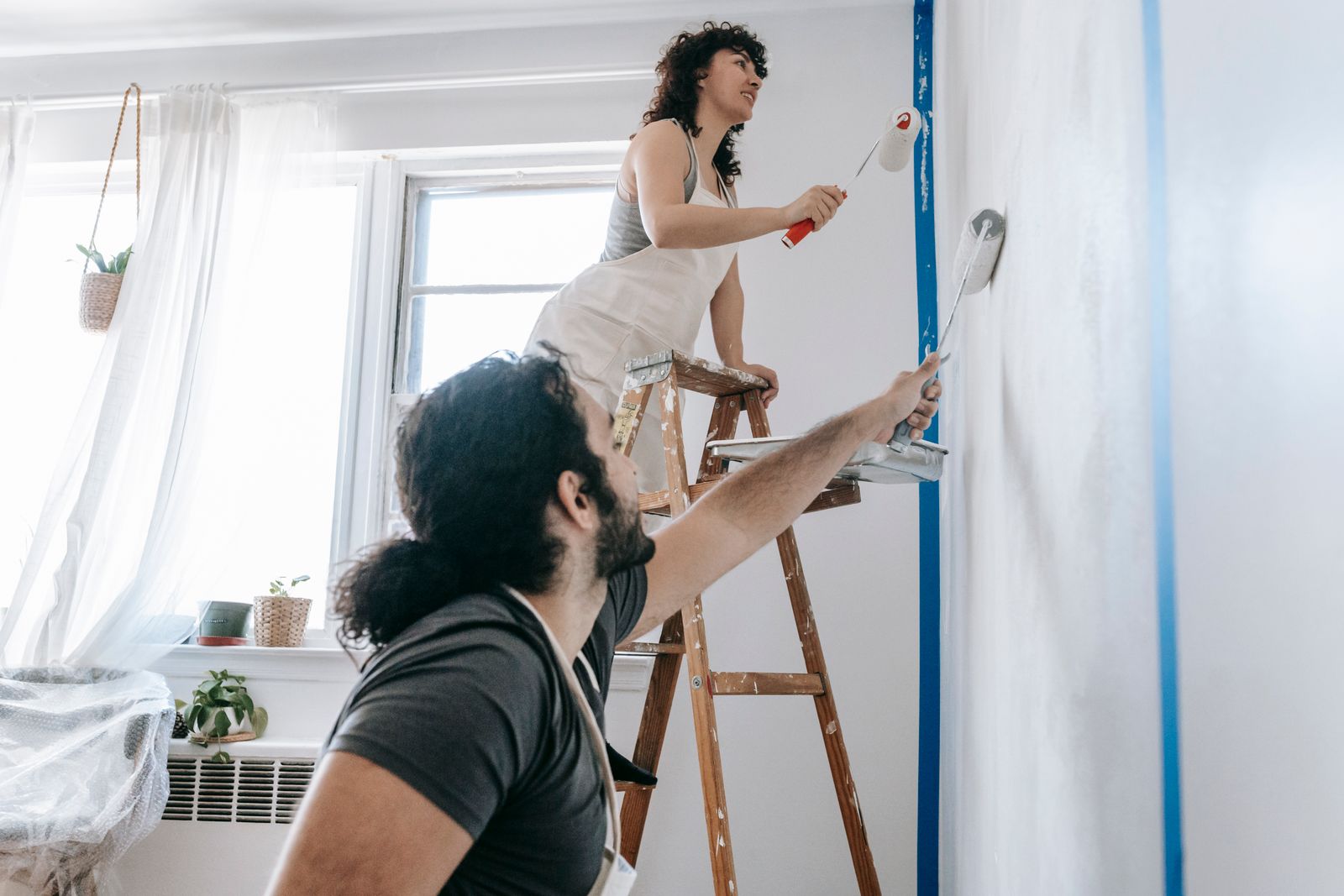 Couple réalisant des travaux de peinture avant de vendre son logement