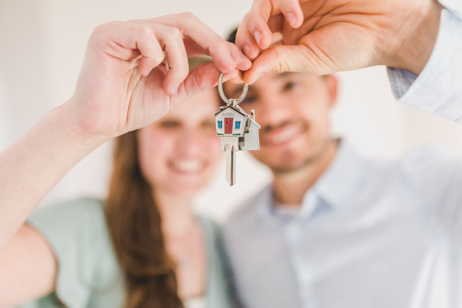 Couple présentant les clés de son nouveau logement après un financement immobilier