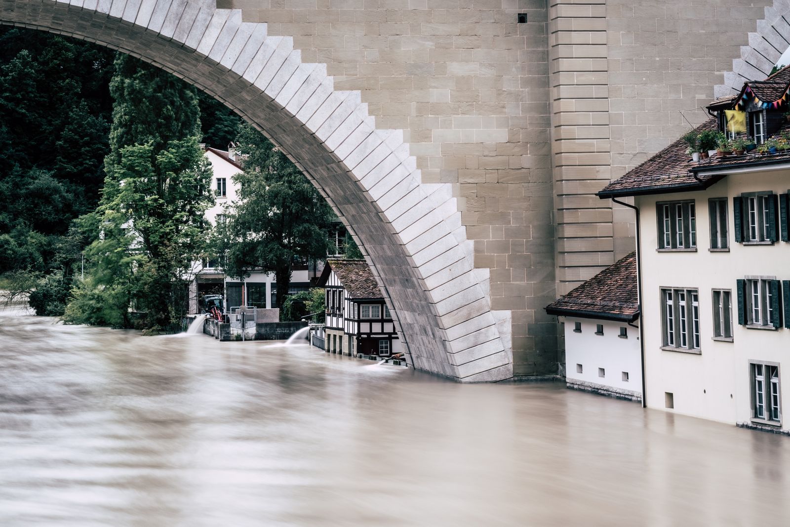 Maisons situées près d’une rivière en crue illustrant le risque d’inondation