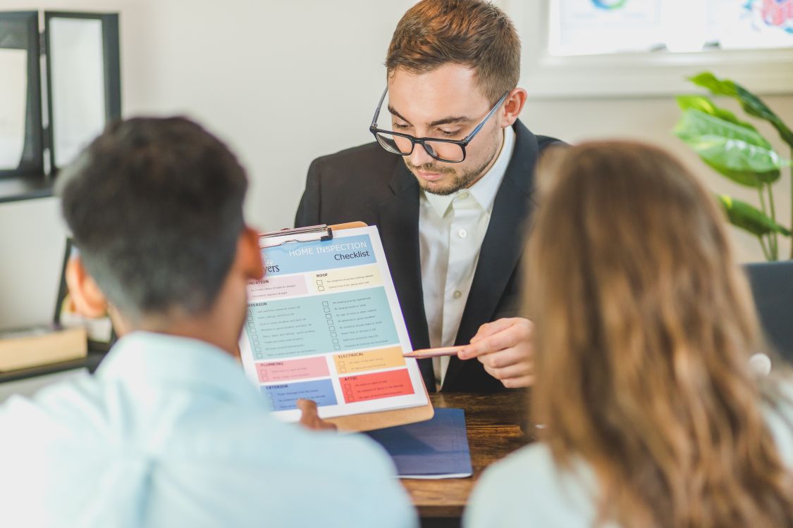 Couple examinant un rapport immobilier avec une professionnelle