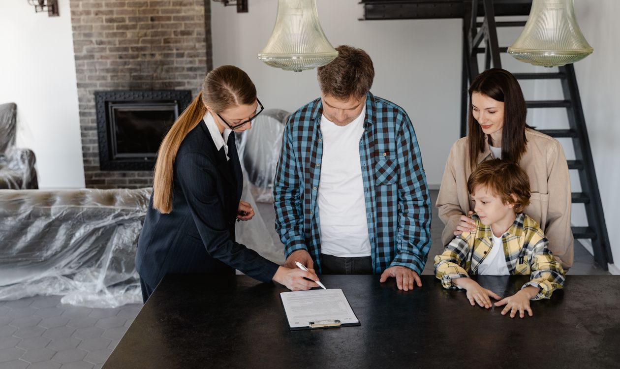 Famille signant une offre d’achat immobilier avec une professionnelle