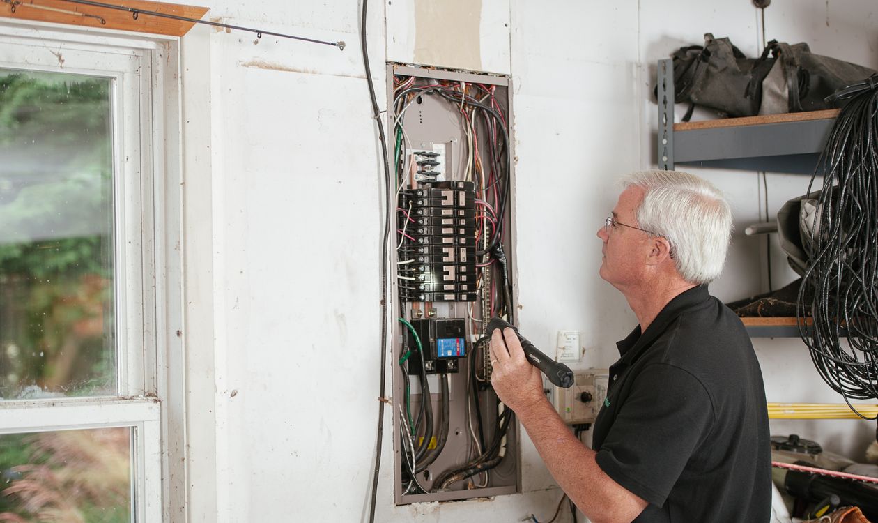 Électricien contrôlant le tableau électrique d’une maison