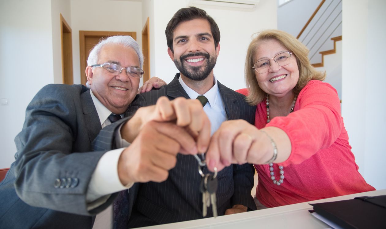Couple de seniors remettant des clés lors d’une vente immobilière en viager