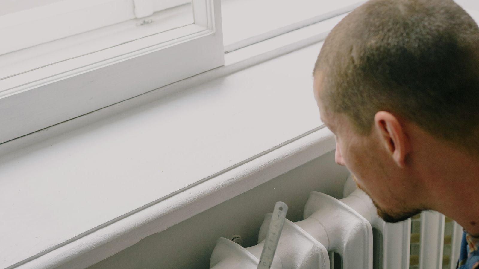 Professionnel contrôlant un équipement de chauffage dans un logement