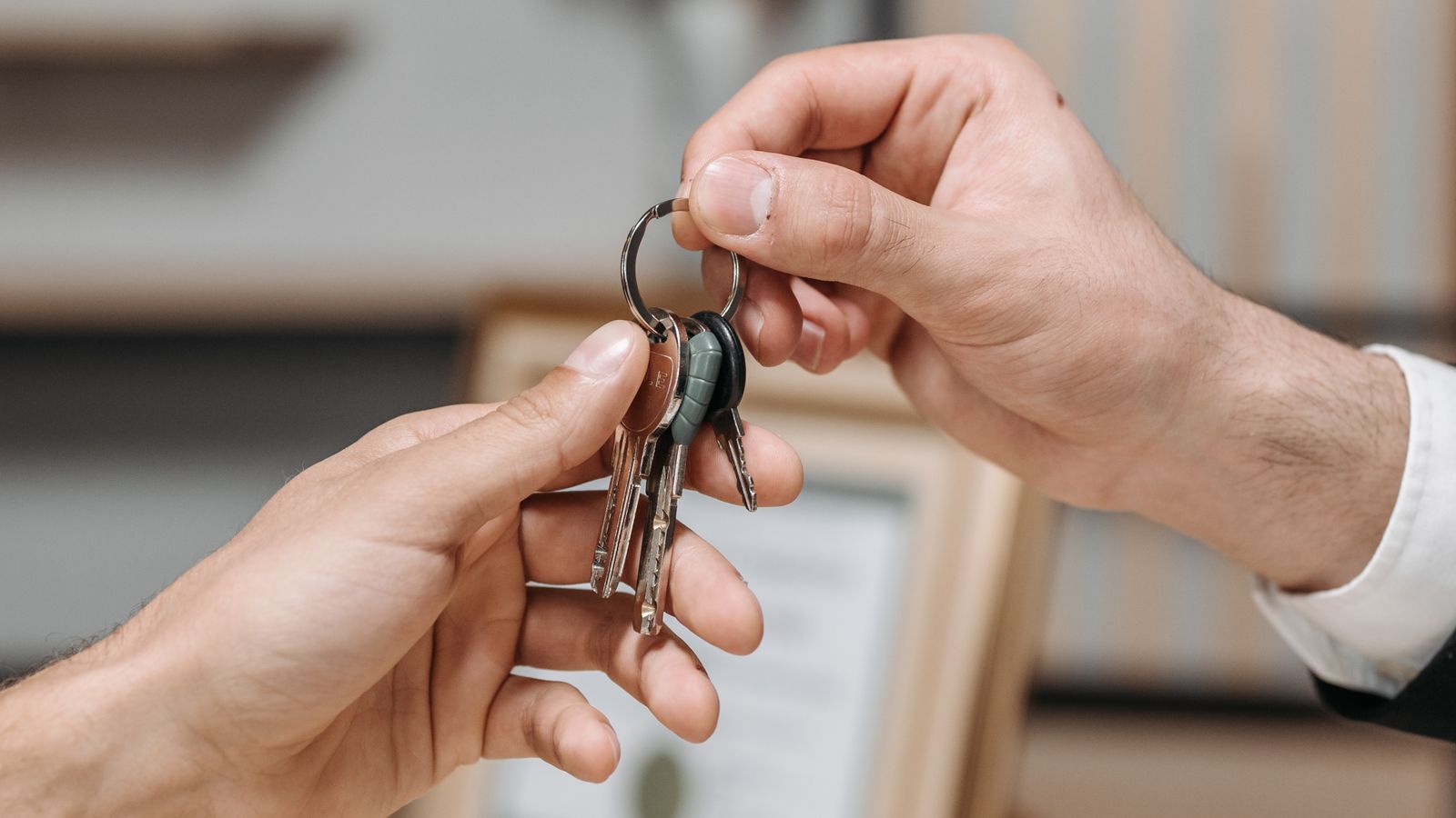 Remise de clés entre un professionnel de l’immobilier et un acquéreur