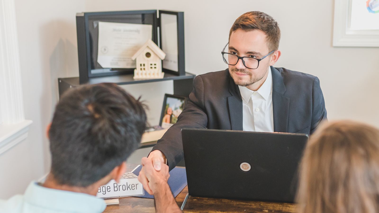 Couple étudiant un dossier de crédit immobilier avec un conseiller