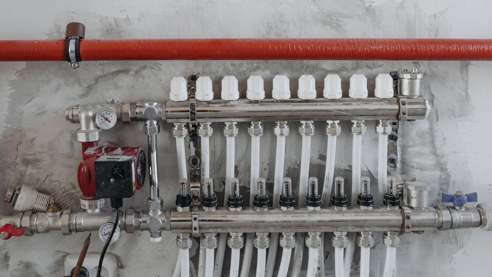 Réseau de tuyaux métalliques et manomètres dans un local de chauffage
