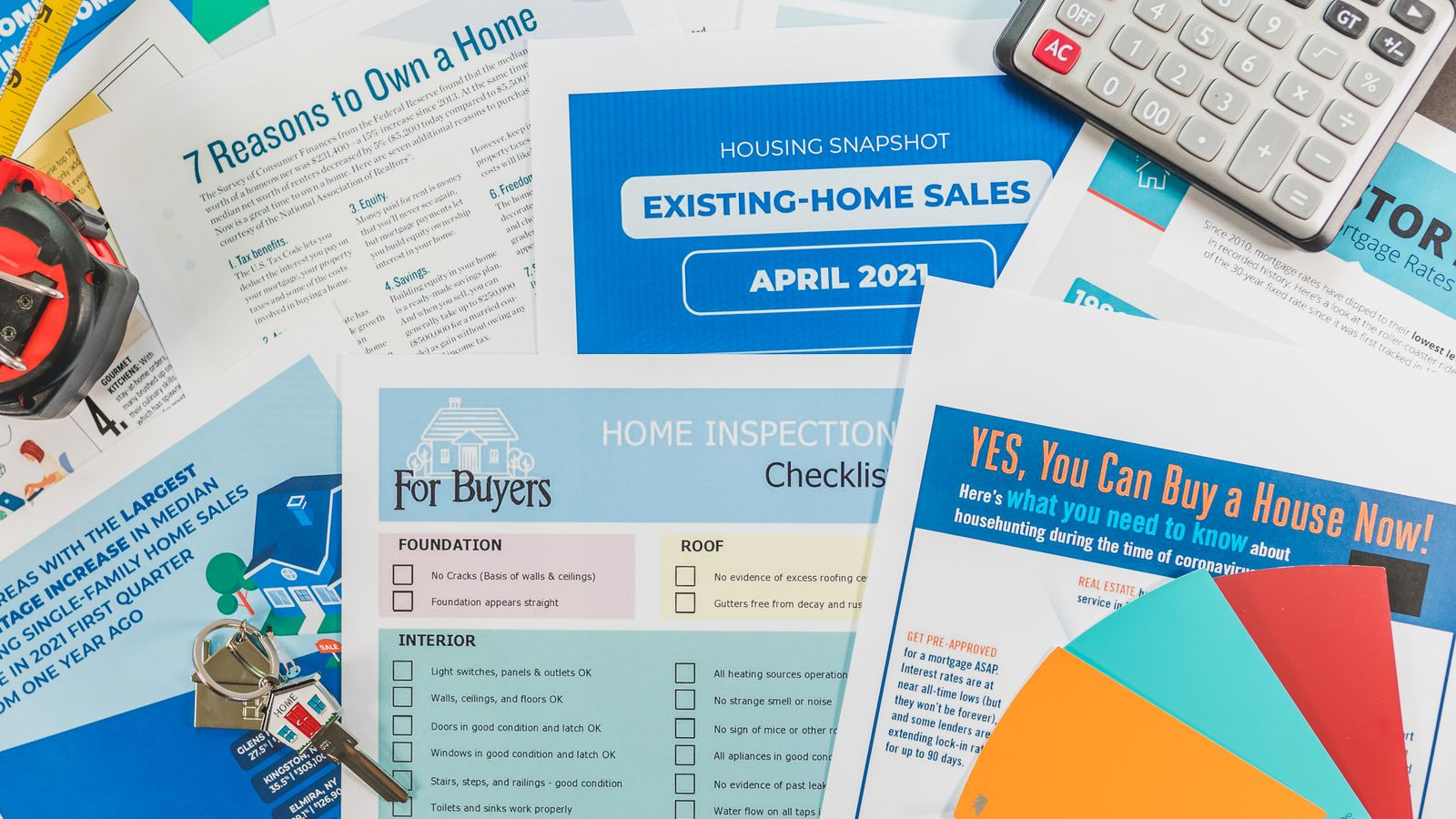 Calculatrice, documents de financement immobilier et nuanciers disposés sur une table