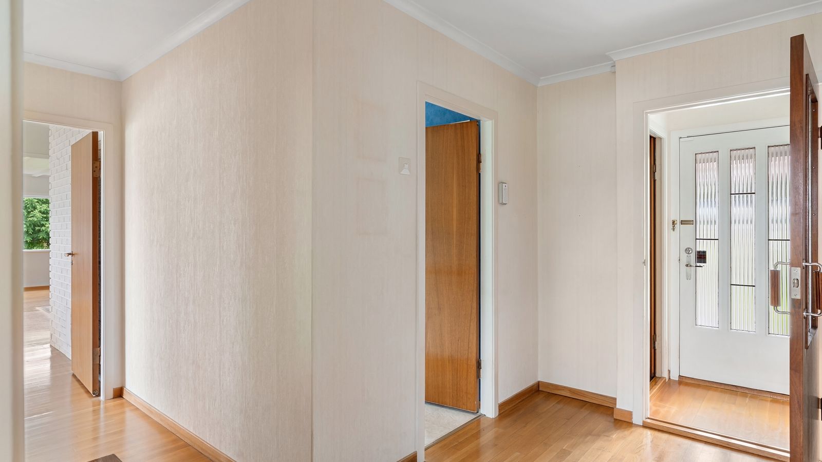 Couloir lumineux desservant plusieurs pièces d’une maison divisée en logements