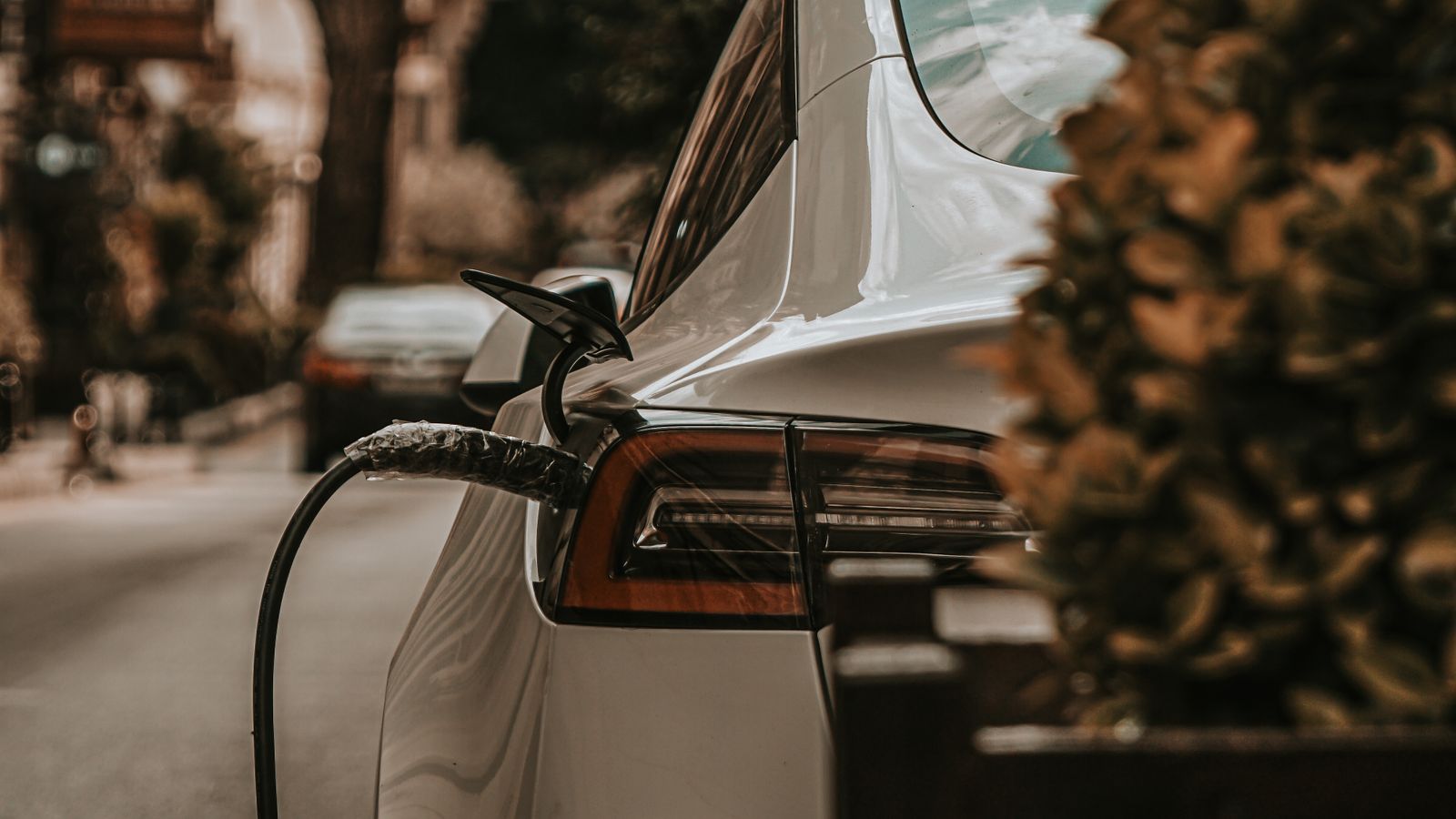Voiture électrique branchée à une borne de recharge près d’un logement