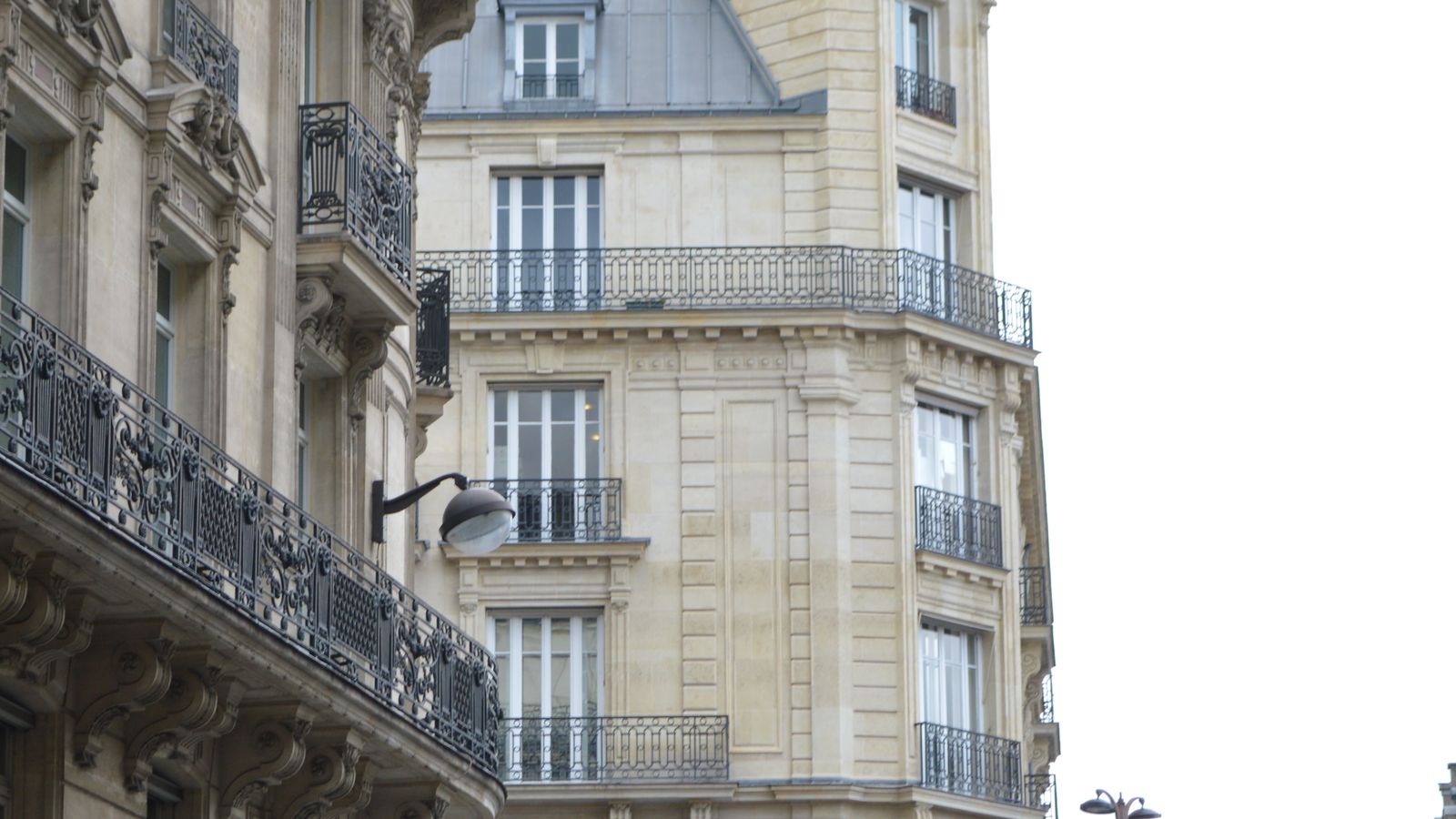 Rue parisienne bordée d’immeubles anciens avec balcons