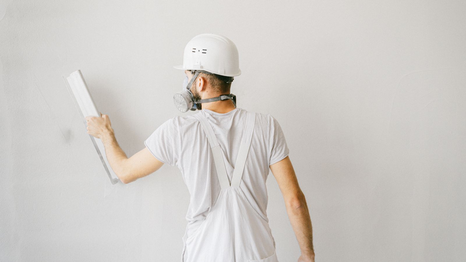 Artisan rénovant une paroi intérieure pour améliorer l’isolation d’un garage attenant