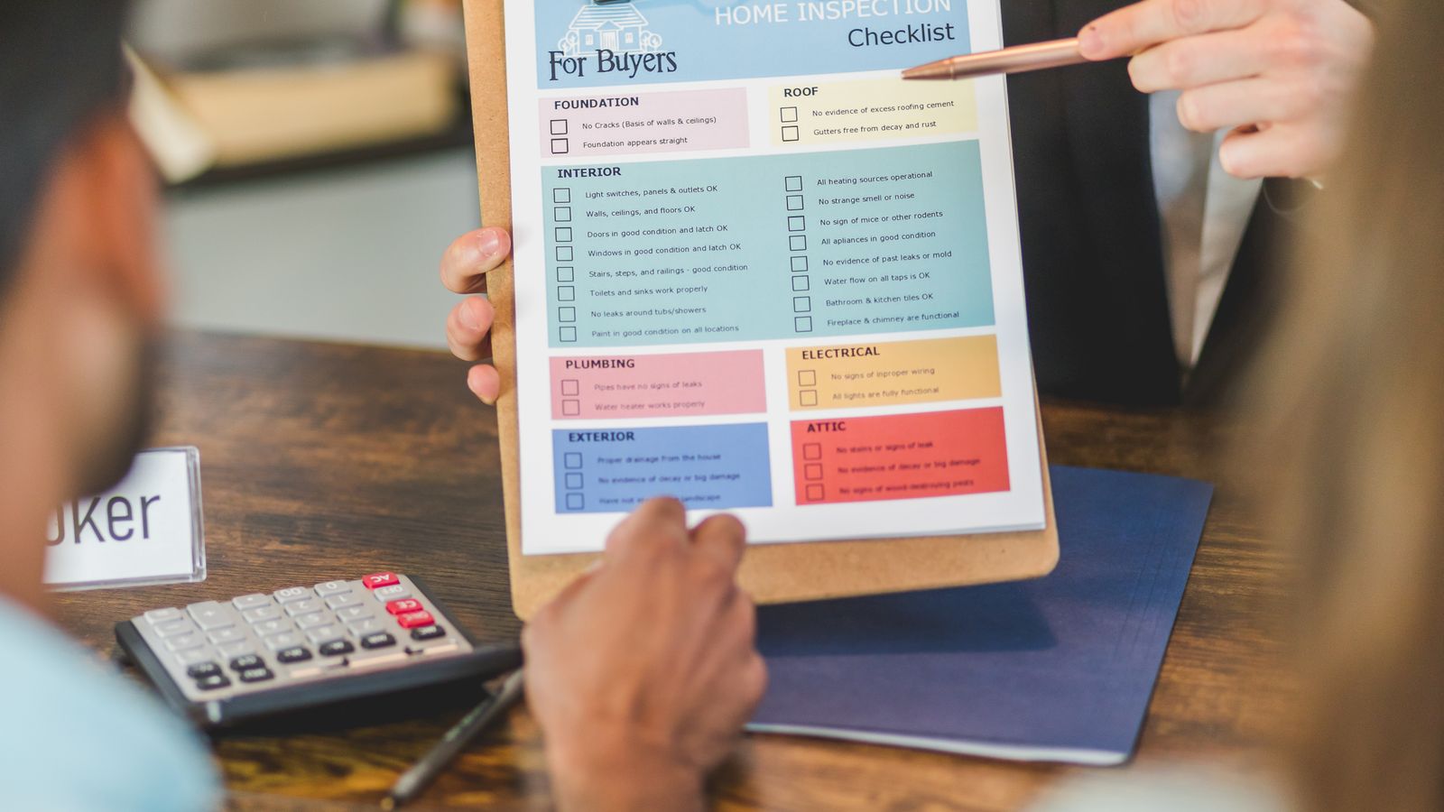 Acheteurs et professionnel examinant une liste de contrôles immobiliers et un budget