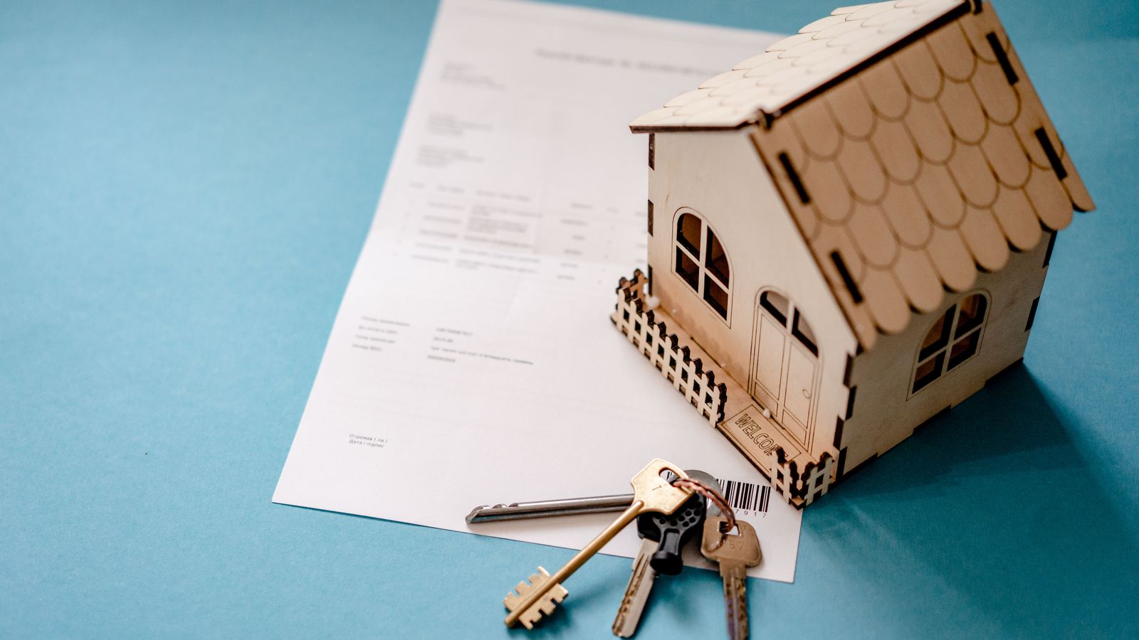 Maison miniature, clés, euros et calculatrice pour estimer un loyer local