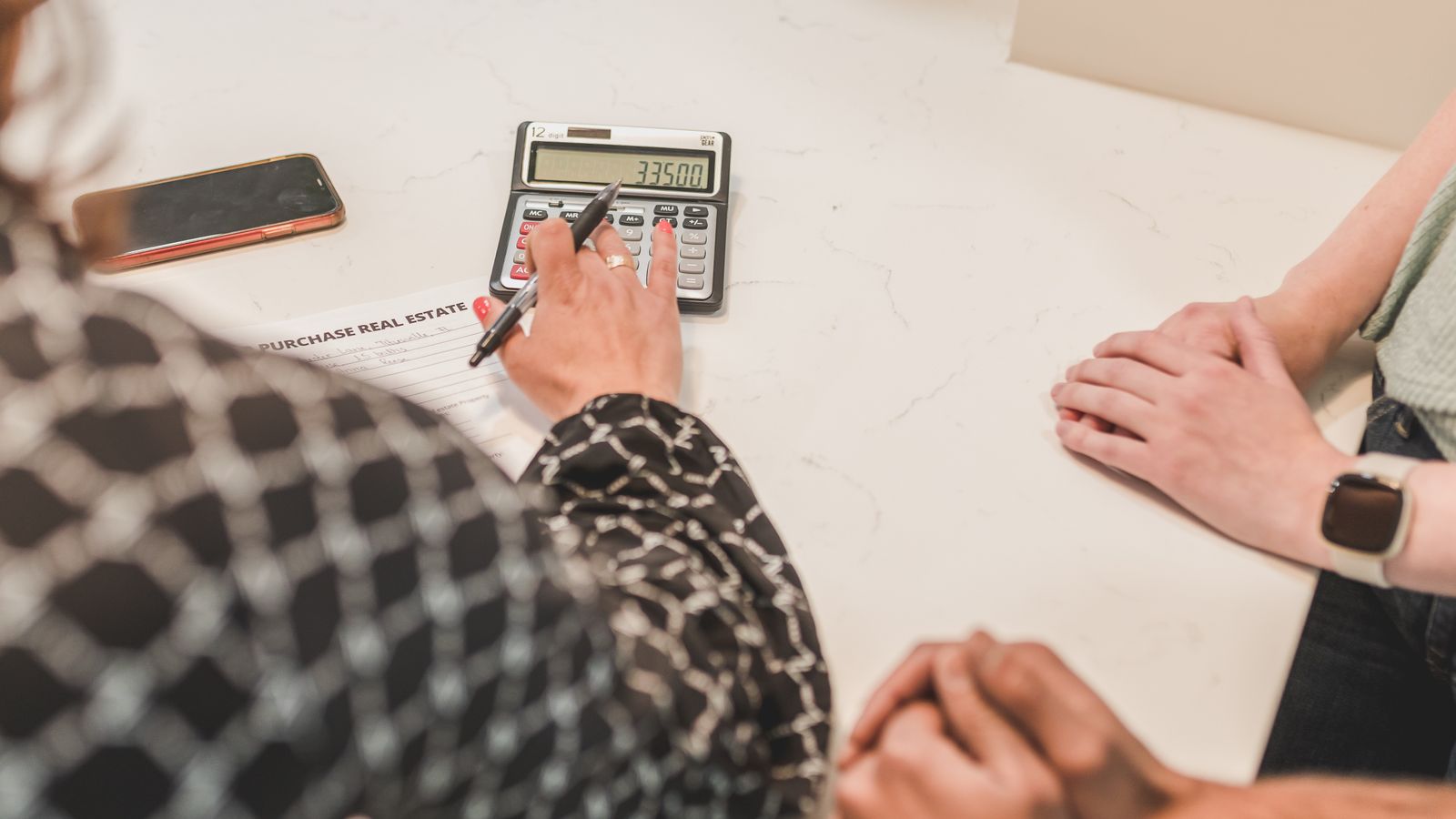 Professionnel calculant le coût d’une prestation immobilière sur des documents