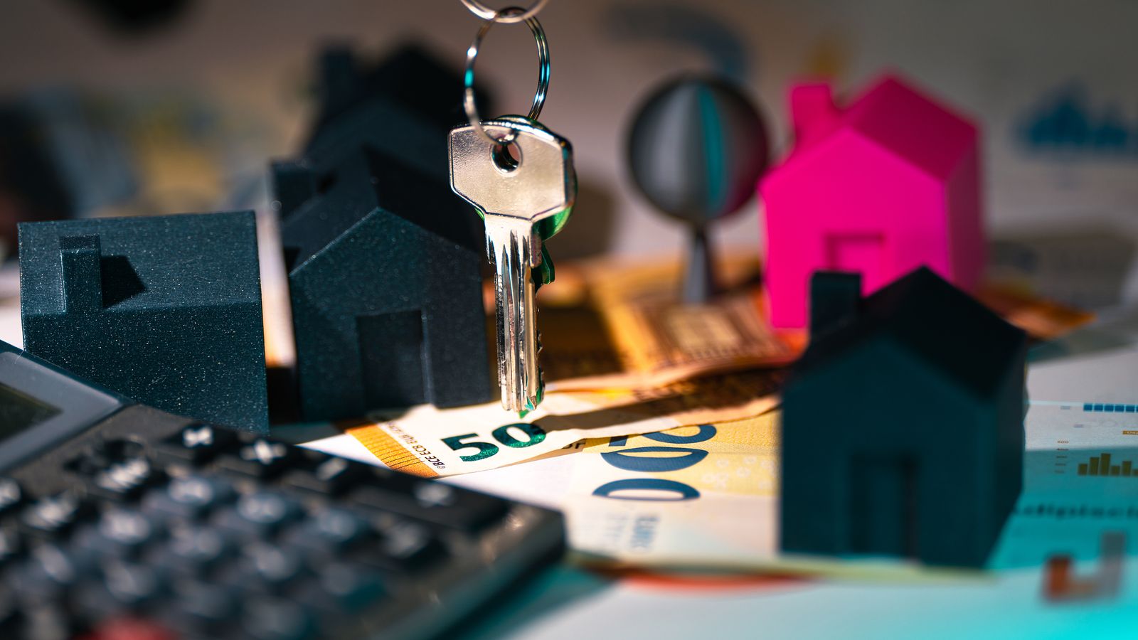 Maisons miniatures, clés, euros et calculatrice pour analyser une vente immobilière