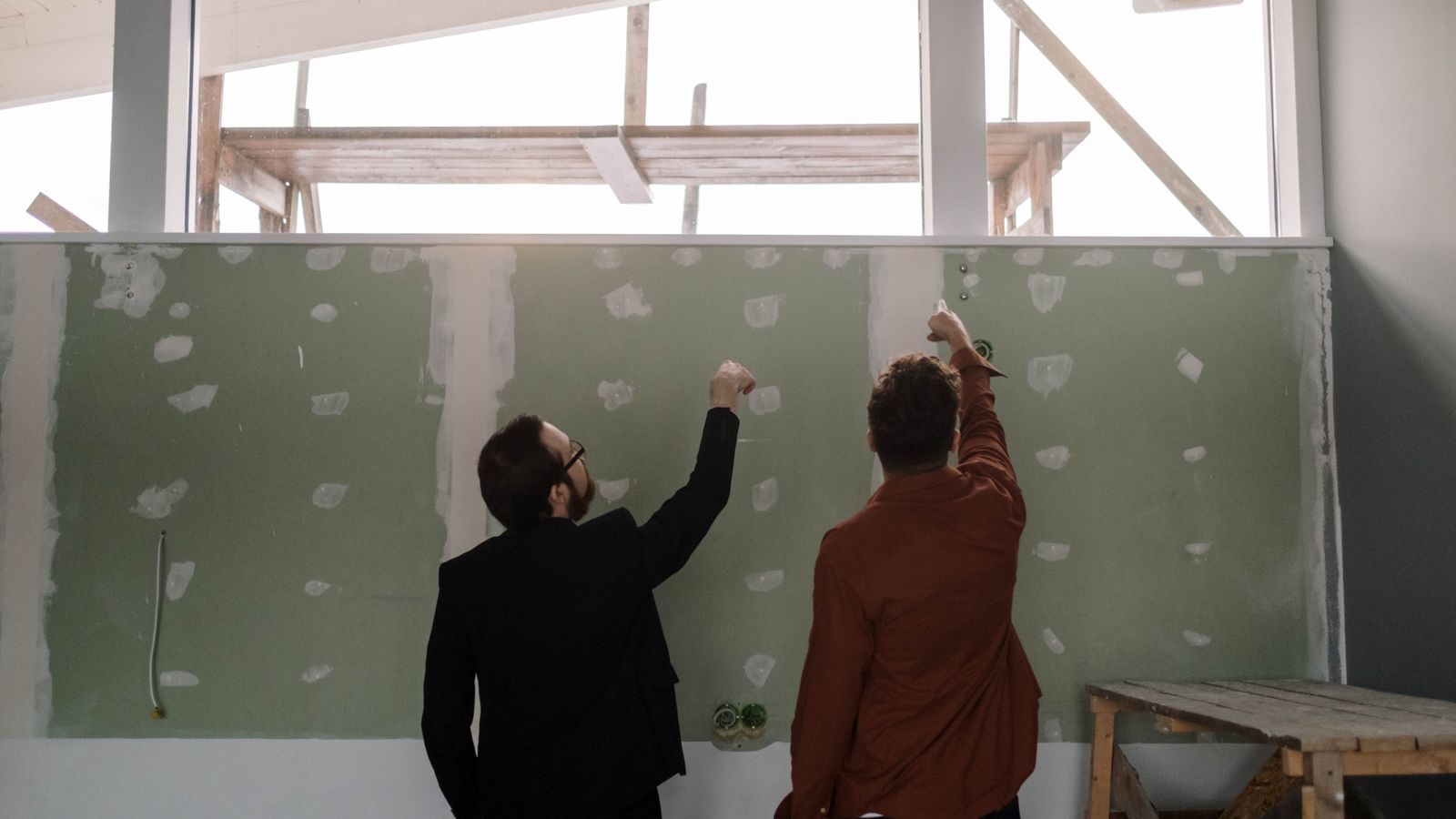 Professionnels examinant un mur intérieur avant des travaux d’isolation