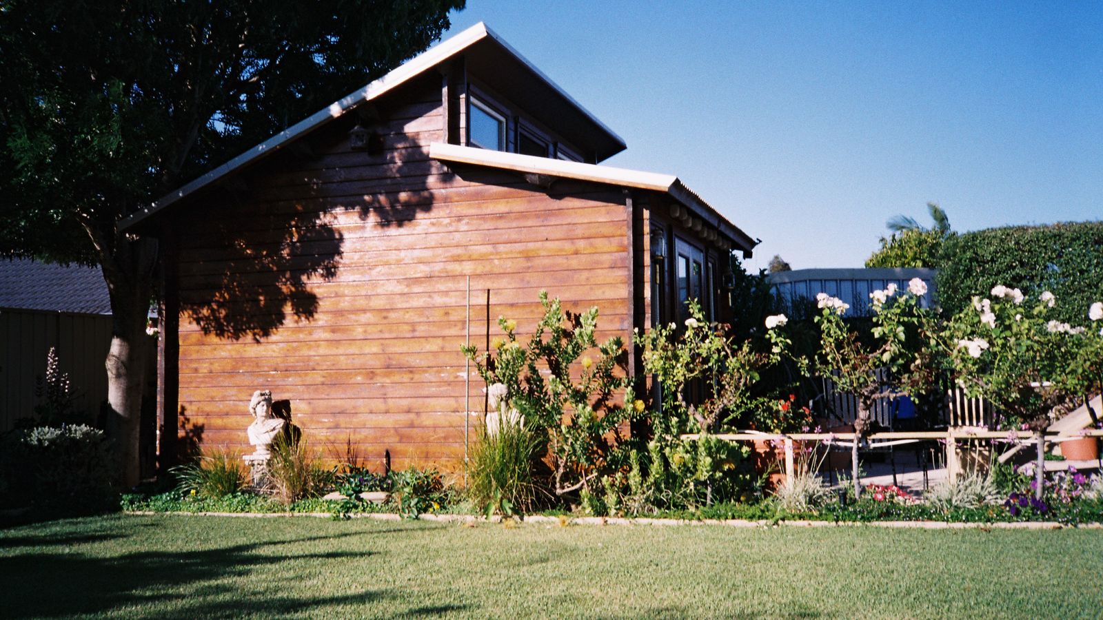 Maison en bois entourée d’un jardin verdoyant