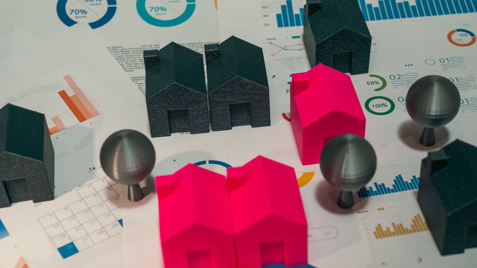 Maisons miniatures et graphiques illustrant les prévisions du marché immobilier