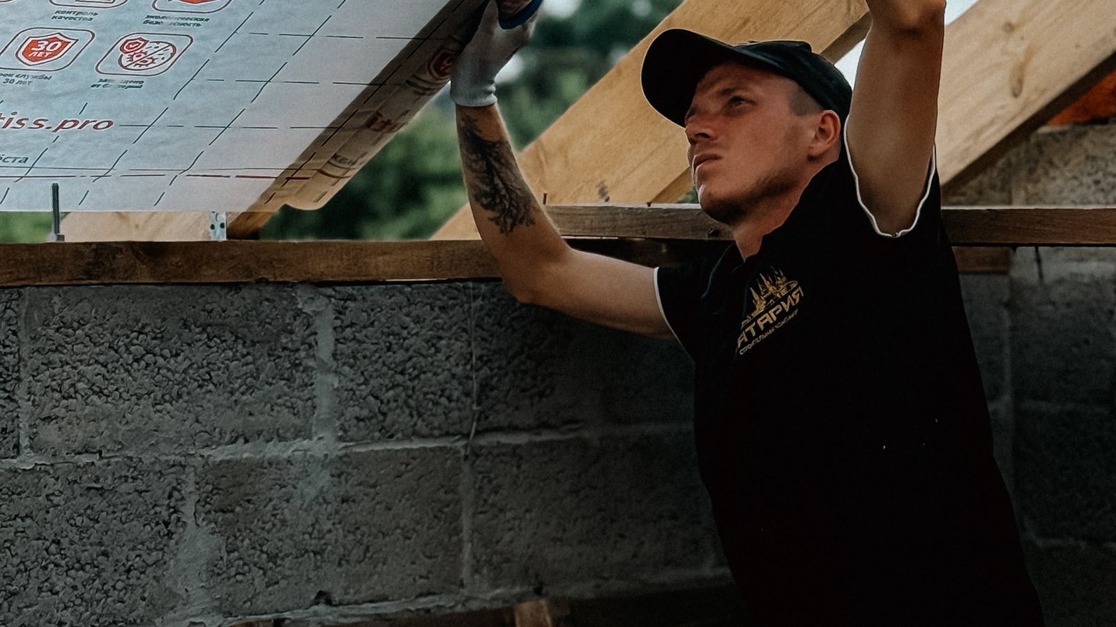 Artisan posant une isolation sous la toiture d'un bâtiment