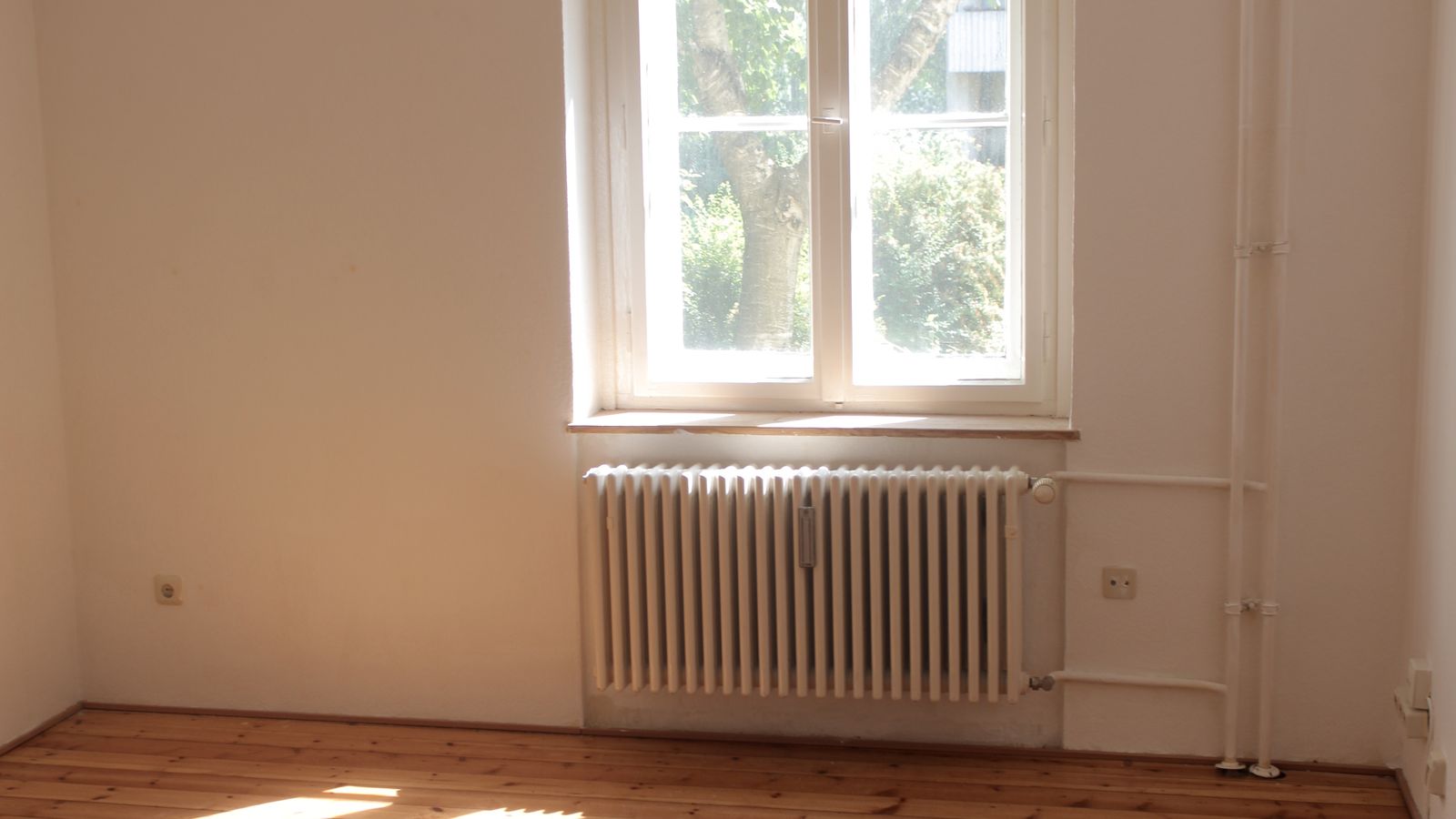 Radiateur sous une fenêtre dans une pièce de vie lumineuse