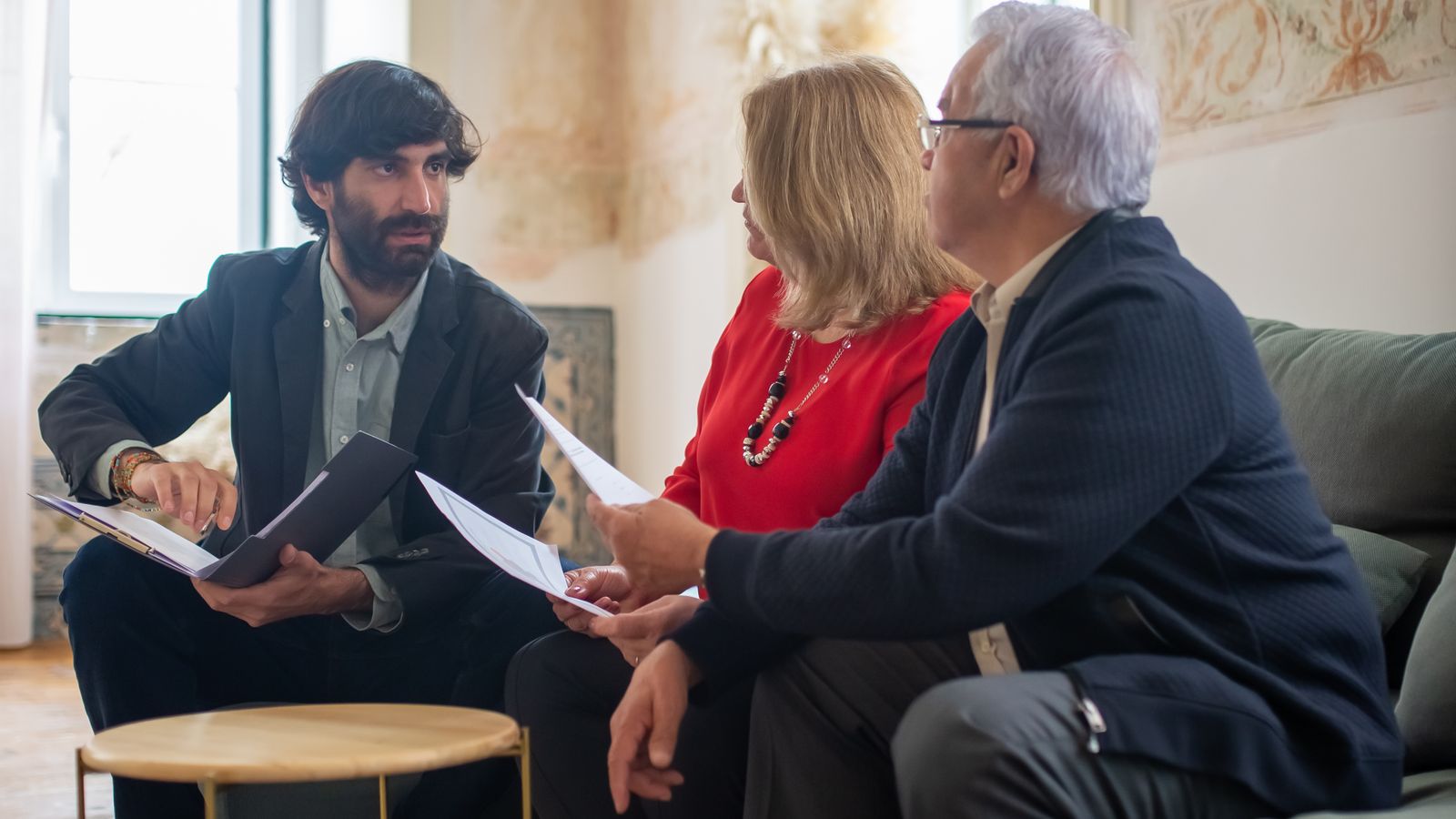 Conseiller présentant des documents financiers à un couple de propriétaires âgés