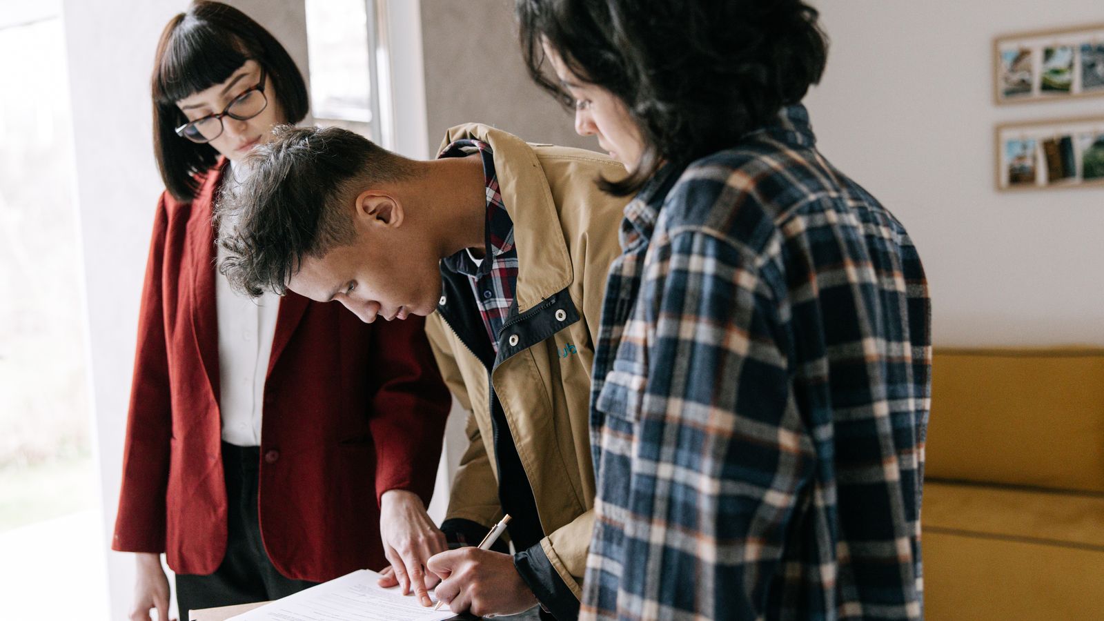 Associés et professionnelle de l’immobilier examinant un contrat de vente