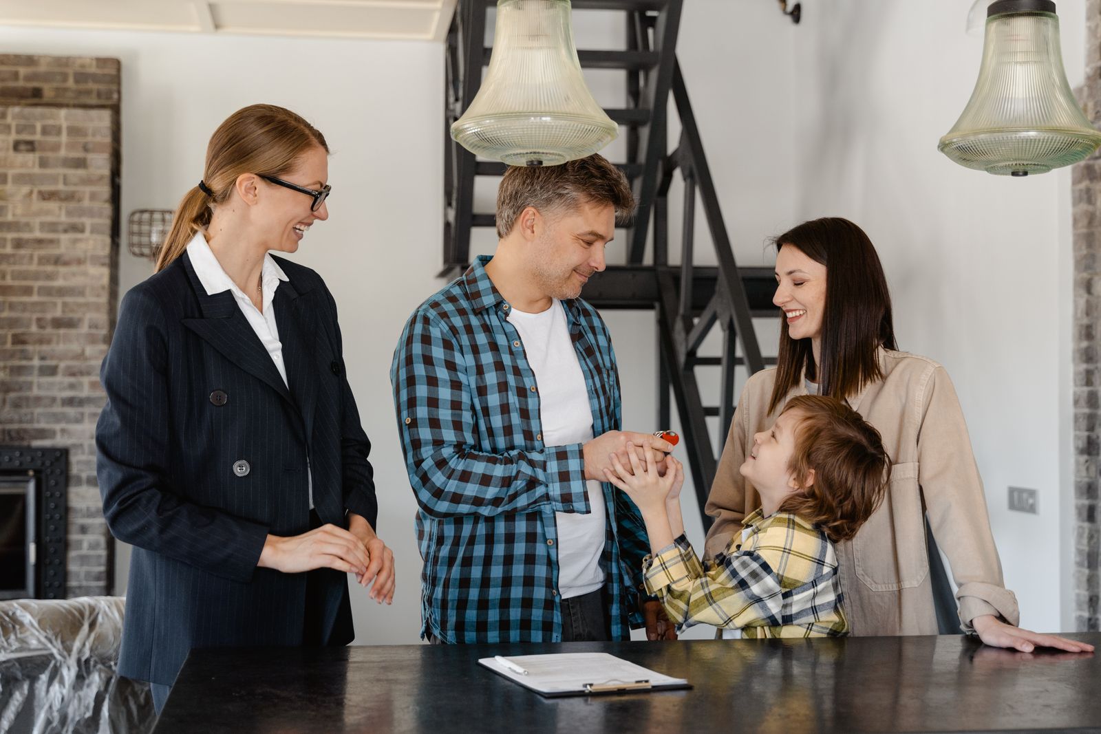 Famille recevant les clés d’un logement avec une professionnelle de l’immobilier