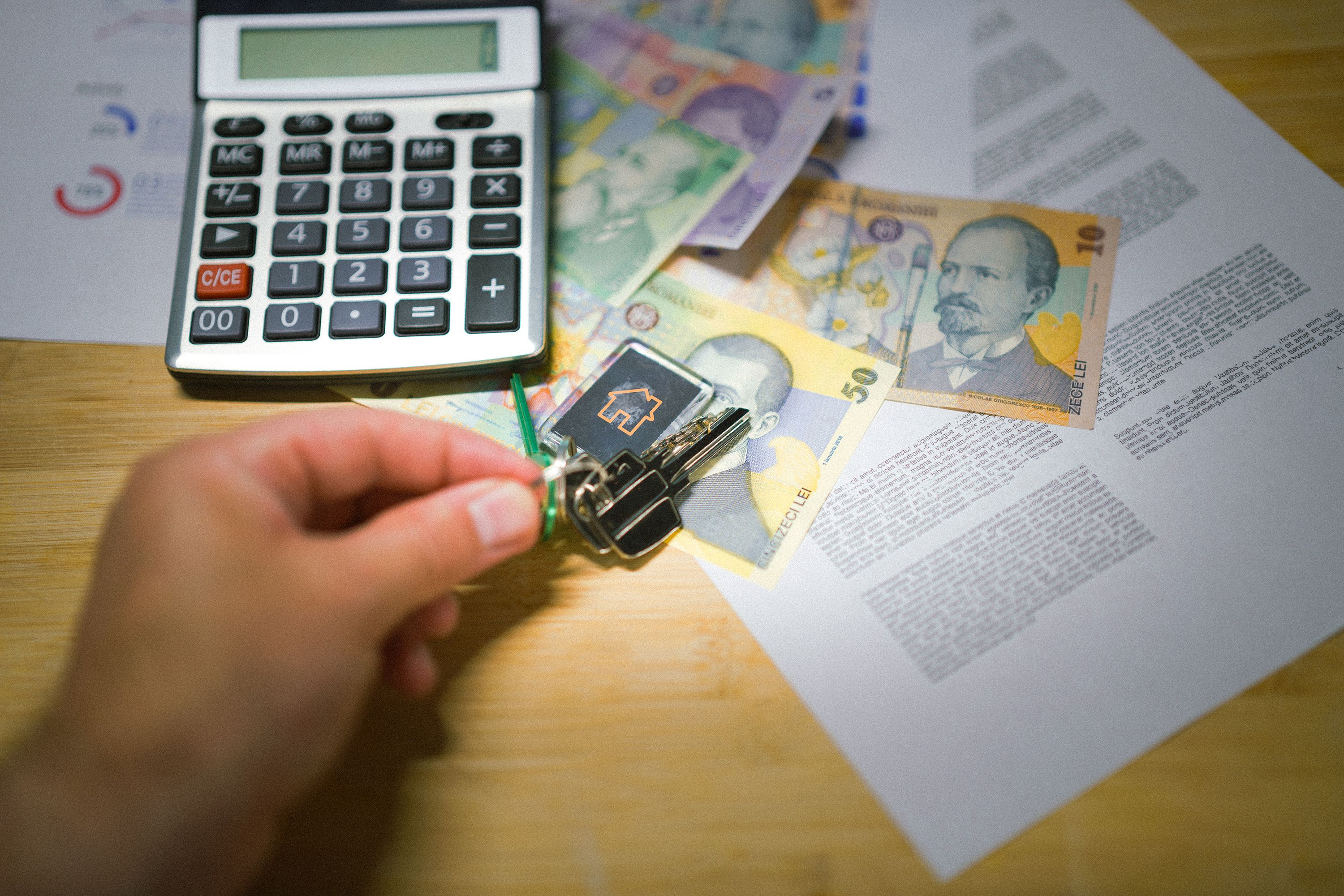 Clés de logement posées près de documents et d’une calculatrice